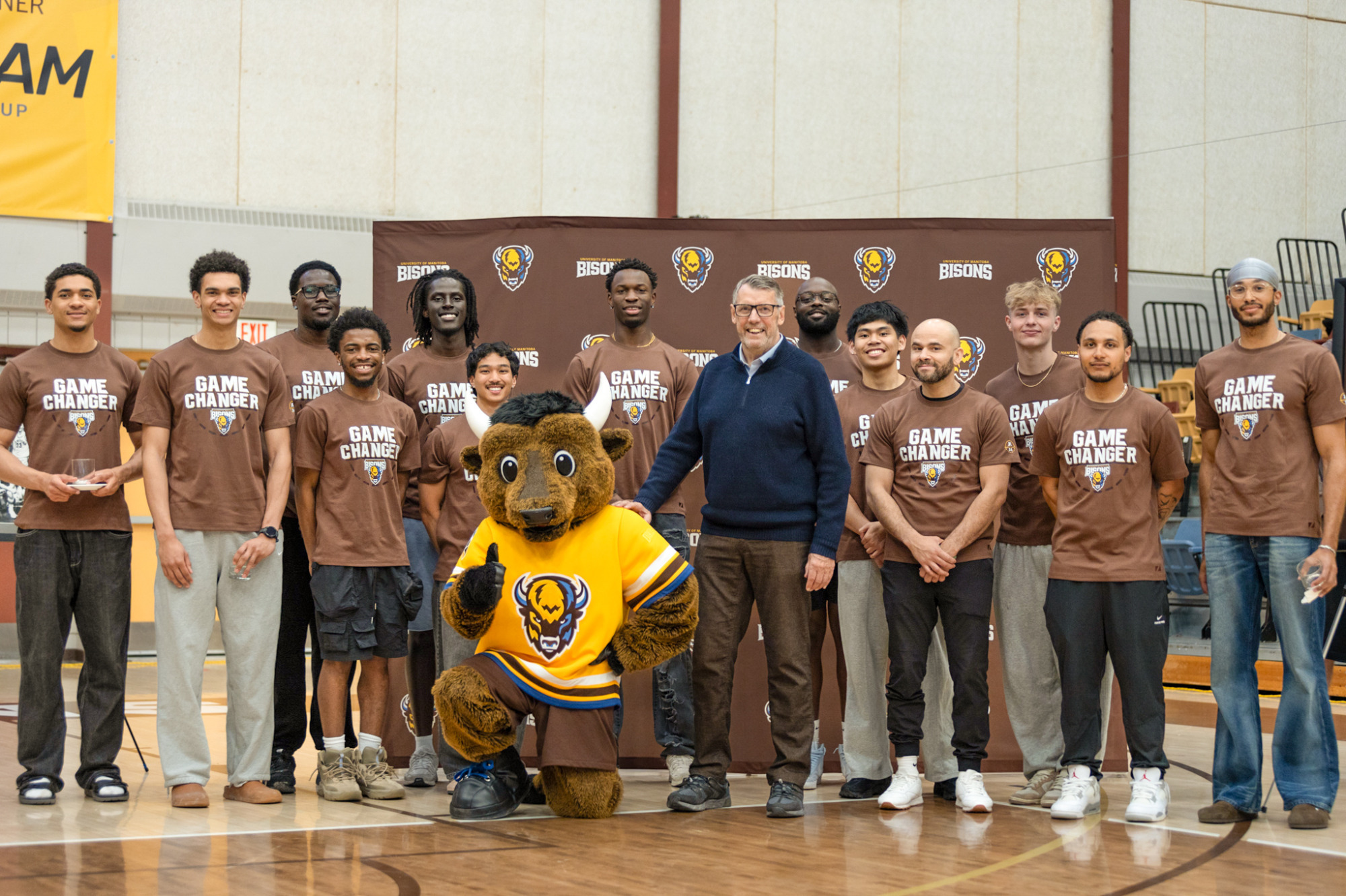 John Loewen with Billy the Bison and the men's basketball team.