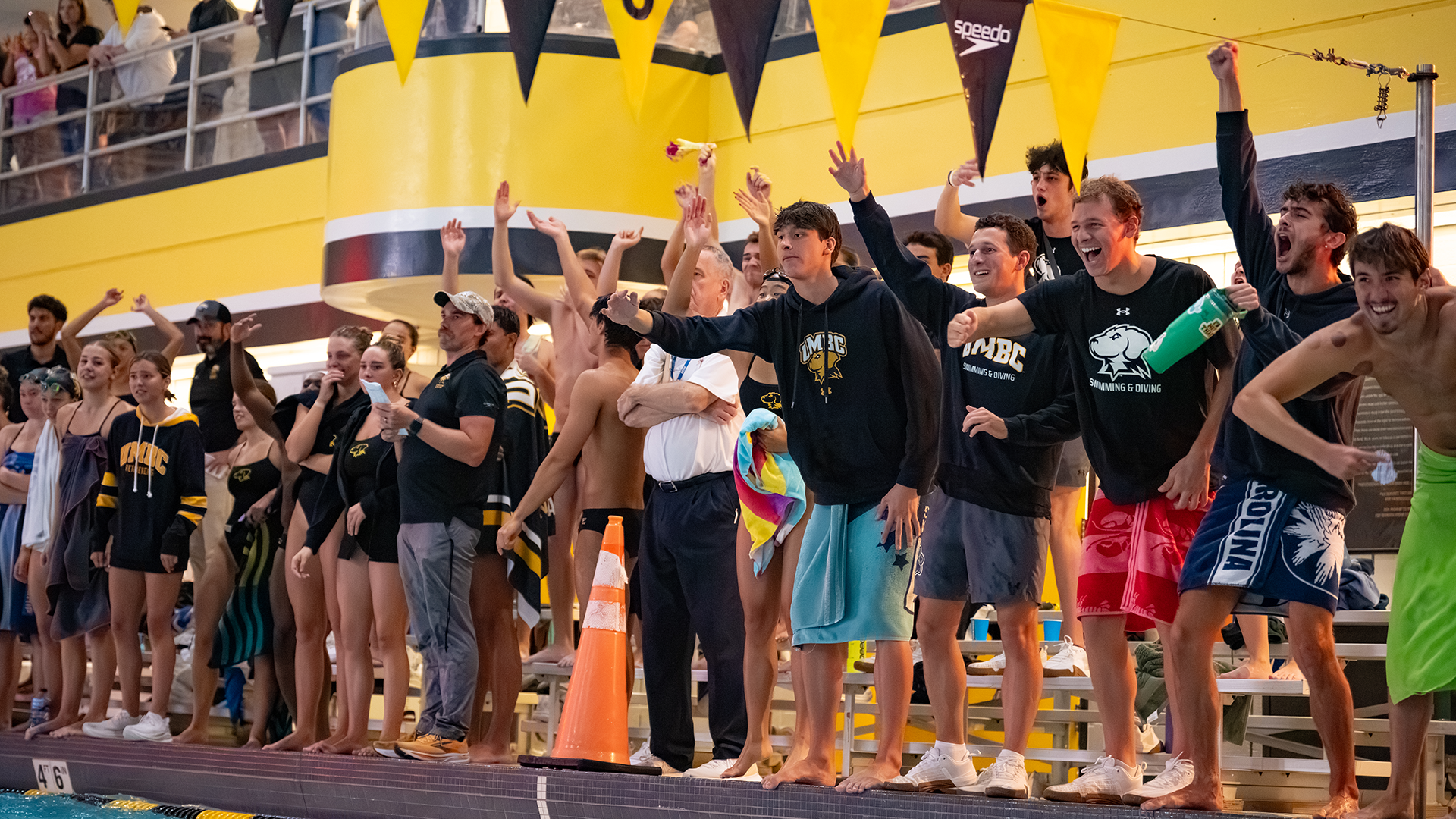 UMBC Swimmers and Divers cheer on their teammates during a race