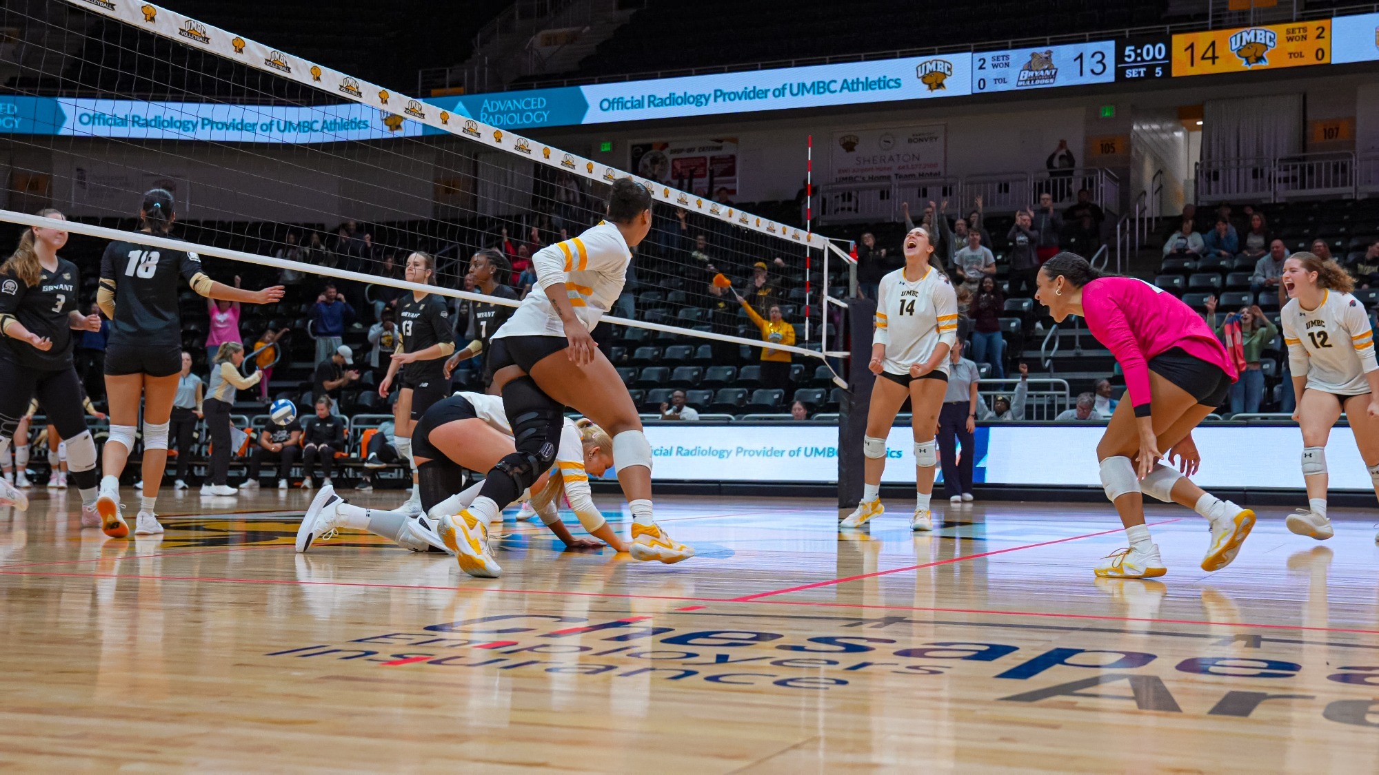 UMBC celebrates the winning point against Bryant