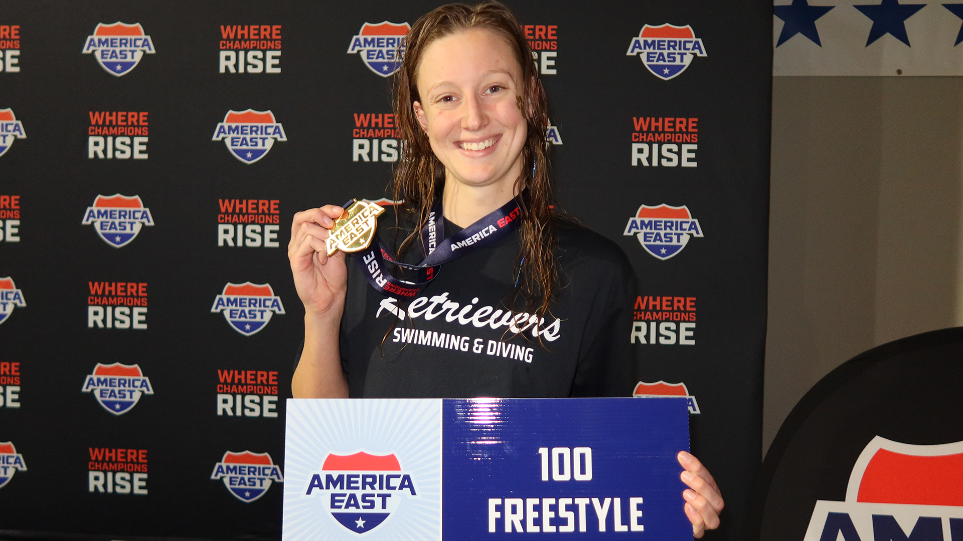 Ashley Gutshall holds her gold medal for winning the 100 free