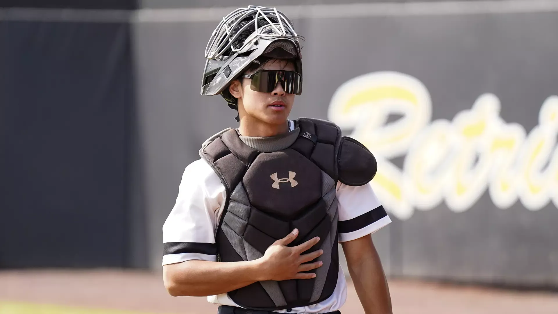 Nico Ong, in his catchers gear, walks back to the dugout