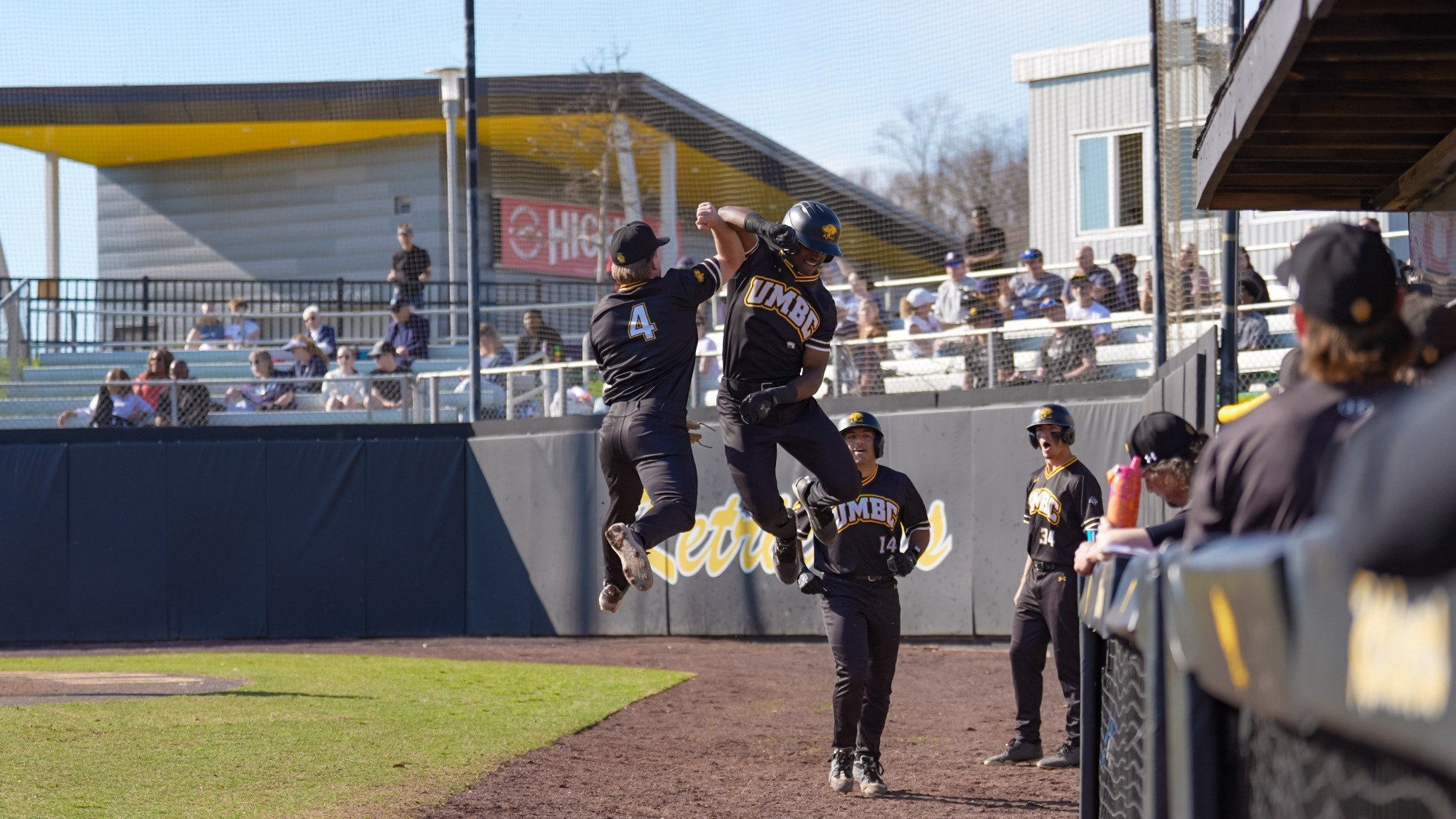 Ehi Okojie and Brooks Henderson jump to high-five after Okojie scores a run