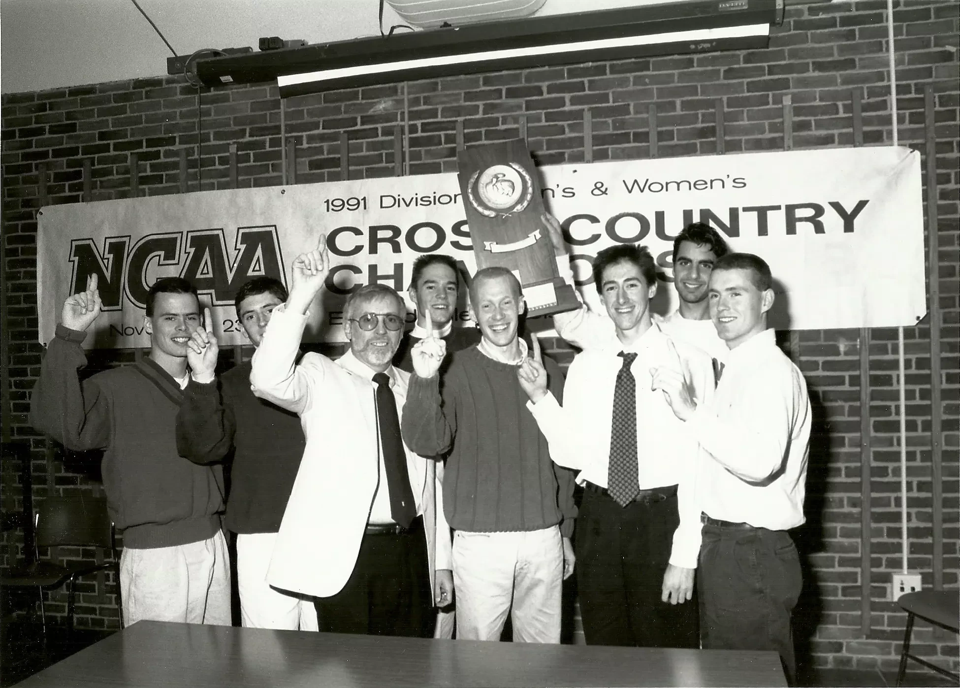 1991 cross country team raising NCAA trophy. 