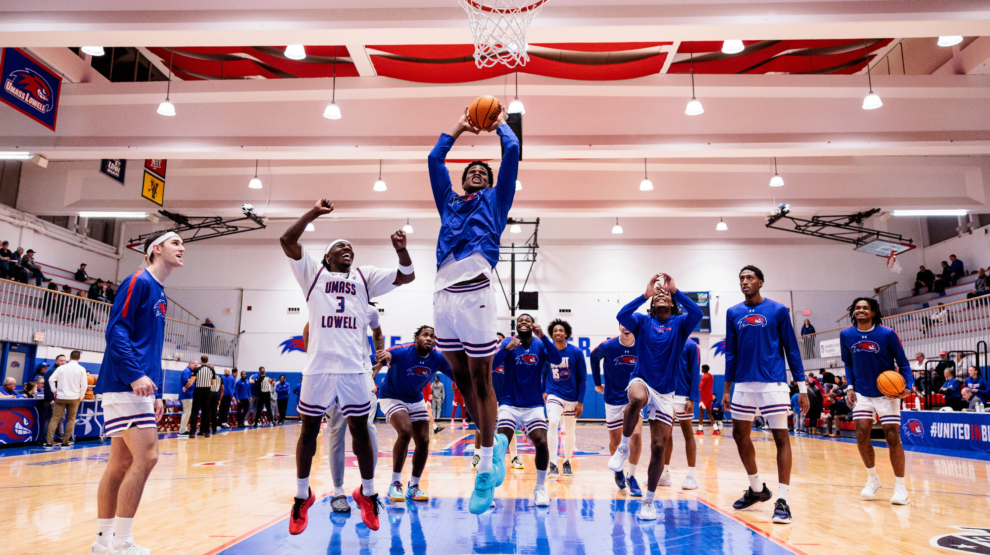 Victor Okojie slam dunk with team around.