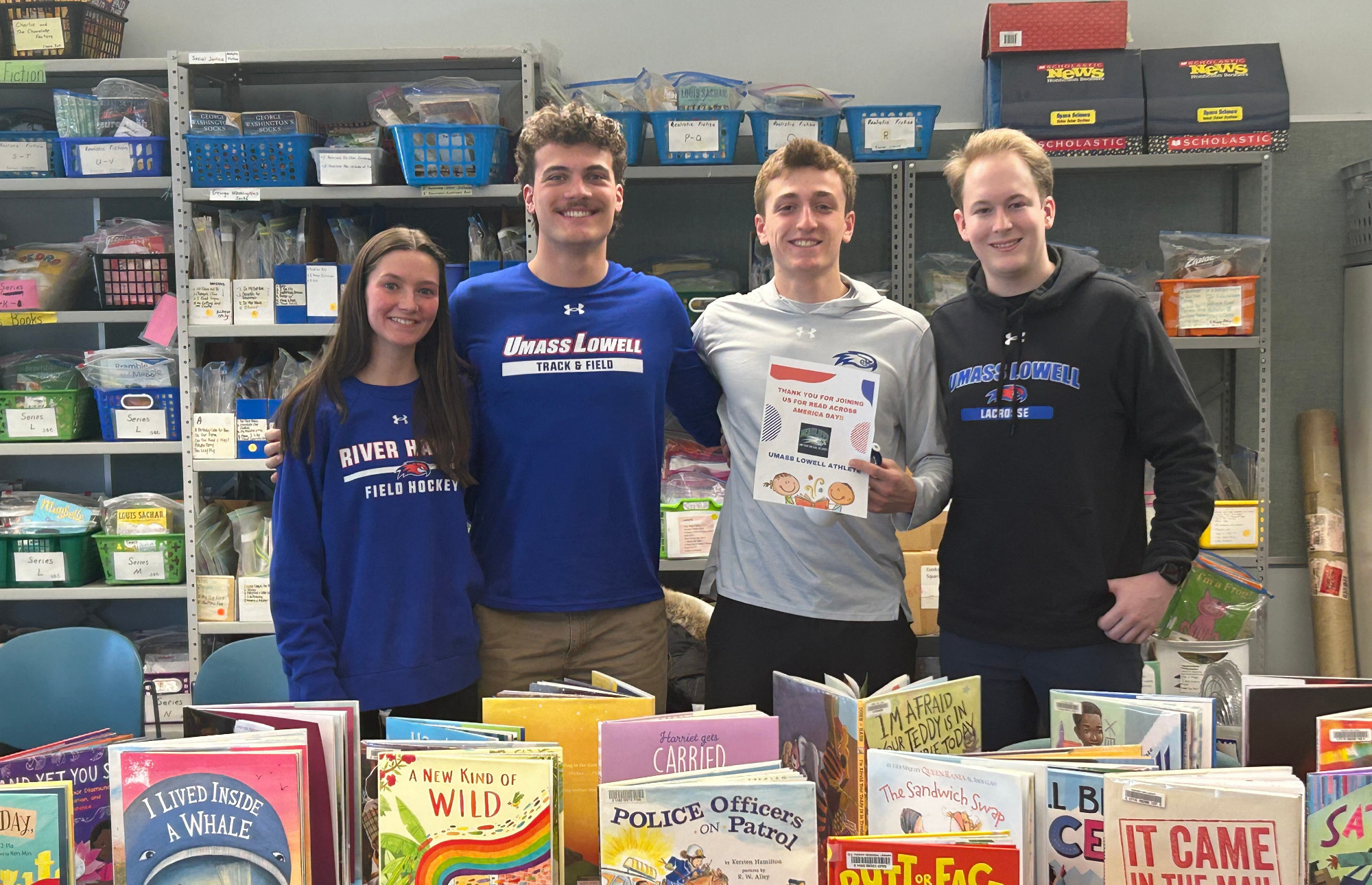 River Hawk athletes pose with books at local school for read across America
