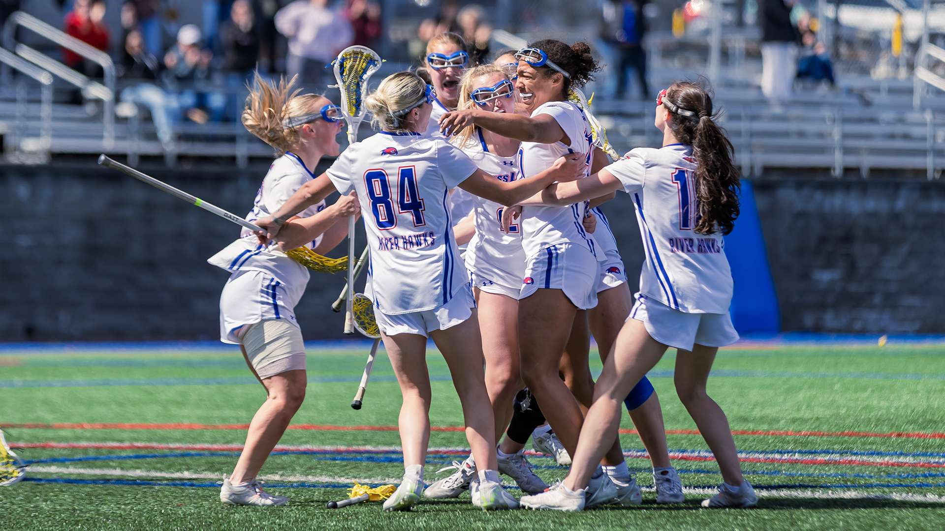 Women's lacrosse group celebration around Pompei after game winning goal in OT over UMBC