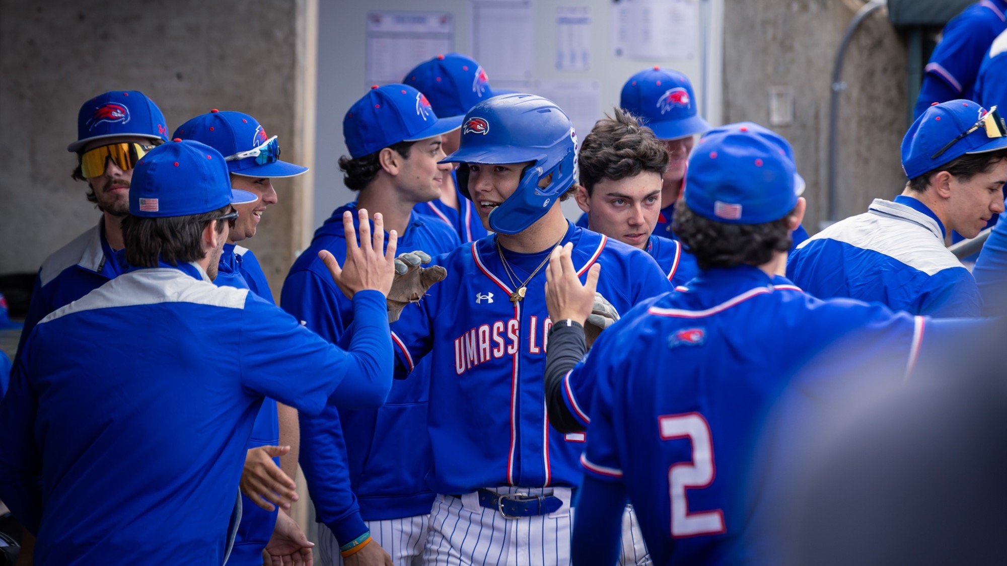 UMass Lowell Baseball players celebrating in the dugout after scoring a run in the game