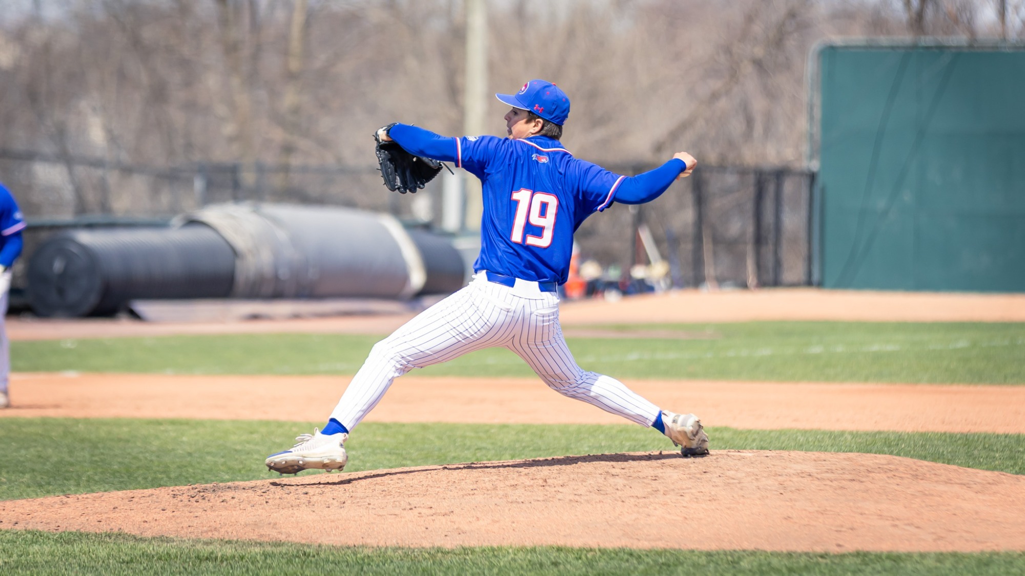 UMass Lowell baseball pitcher standing on a mound and is about to throw the ball down the plate with a batter in the box