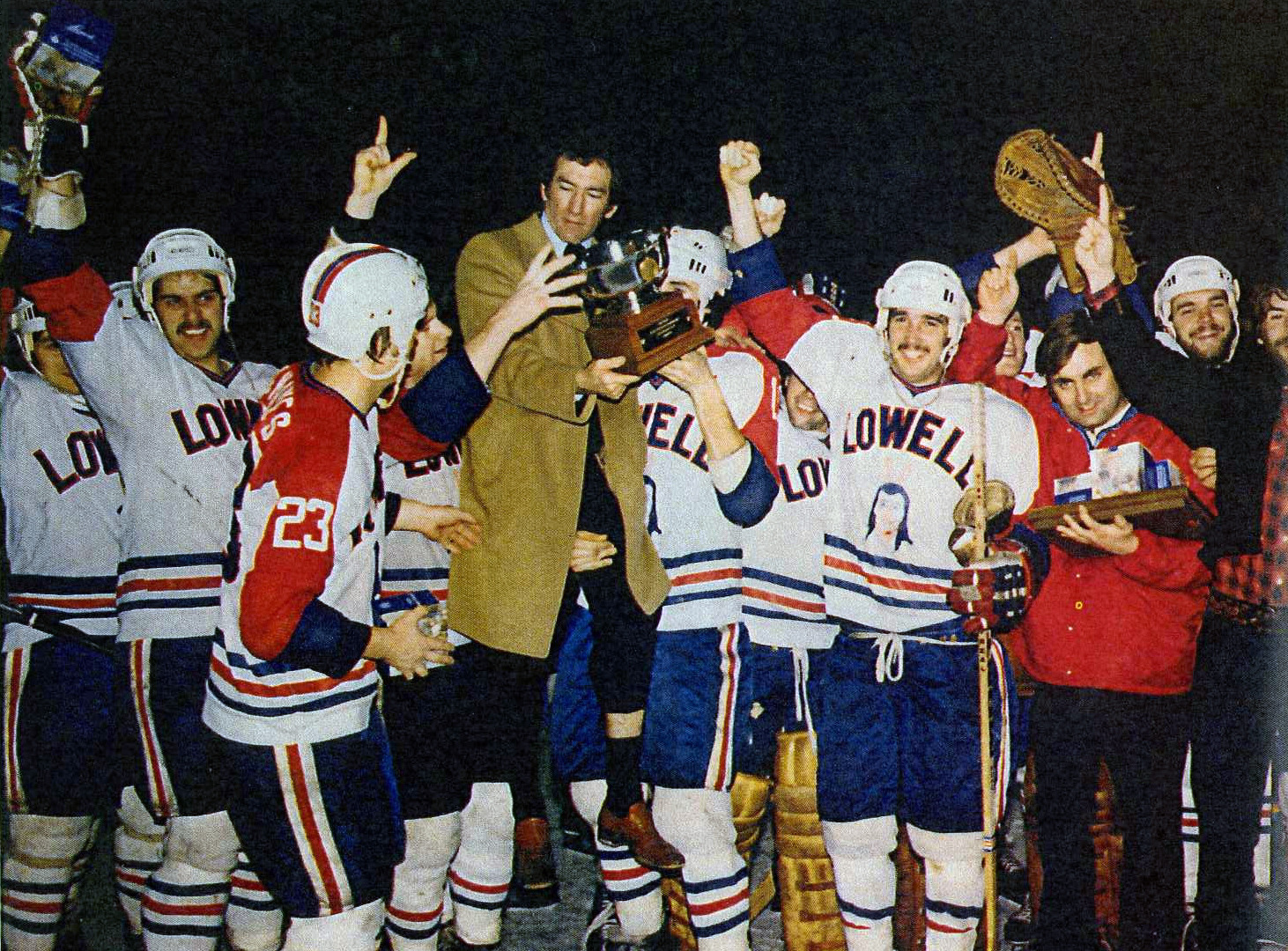 Billy Riley holding trophy being lifted up by players
