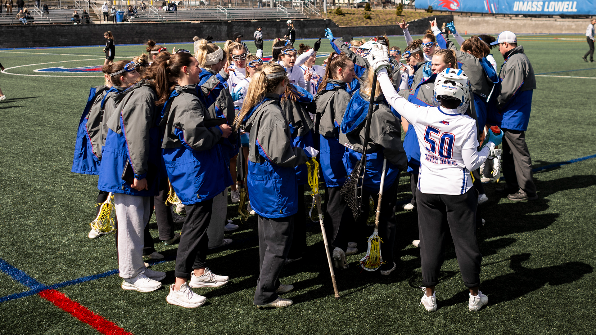 Women's lacrosse team huddled up before game against Bryant