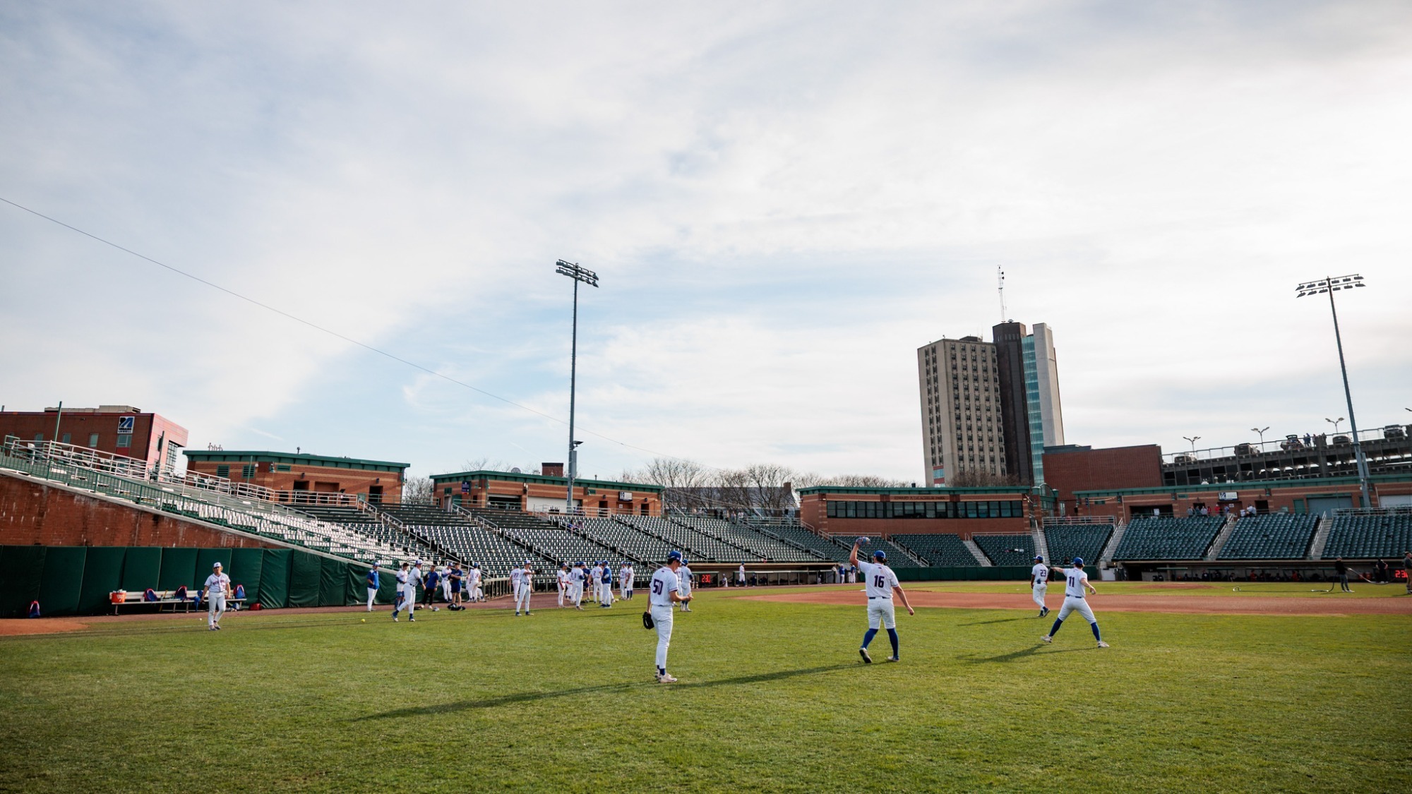UMass Lowell baseball players on their home ballpark Edward A. LeLacheur Park warming up before a game