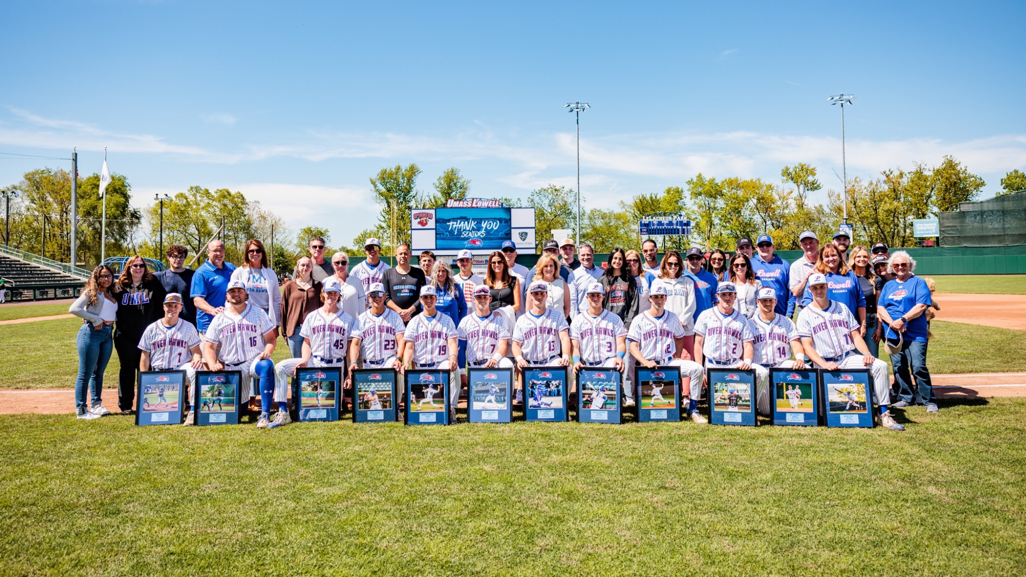 UMass Lowelll baseball seniors and graduate students taking a group photo on the first base line on Senior Day at Edward A. LeLacheur Park