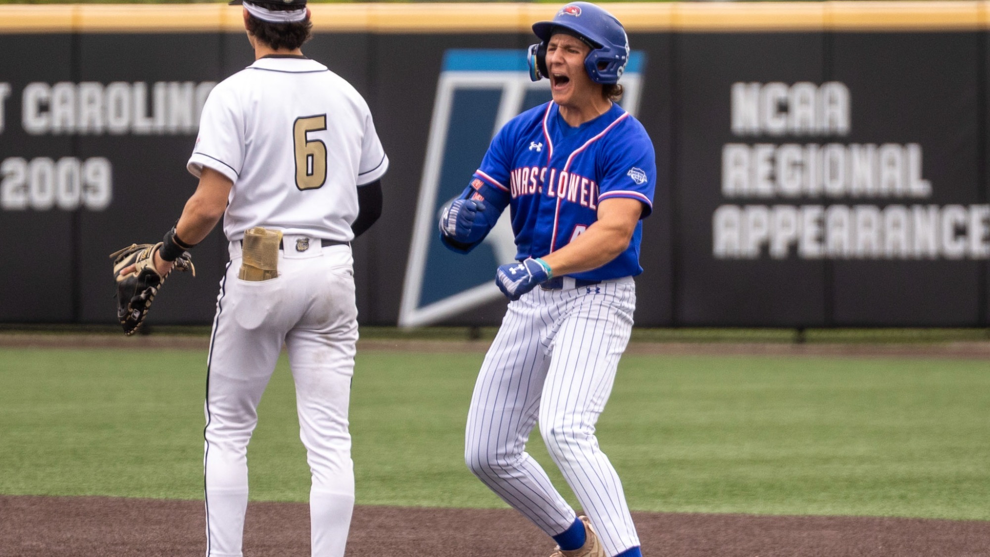 UMass Lowell Baseball player yelling and celebrating on first base after recording a hit in the game against Bryant