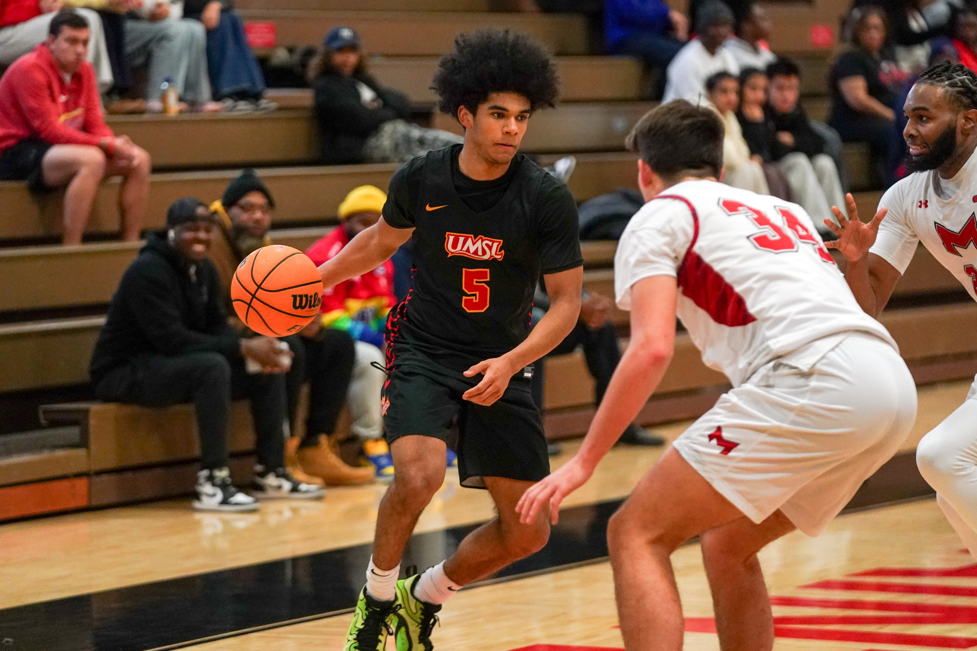 Taye Moore looks to drive the basketball against a Maryville defender in a game from December 9, 2025