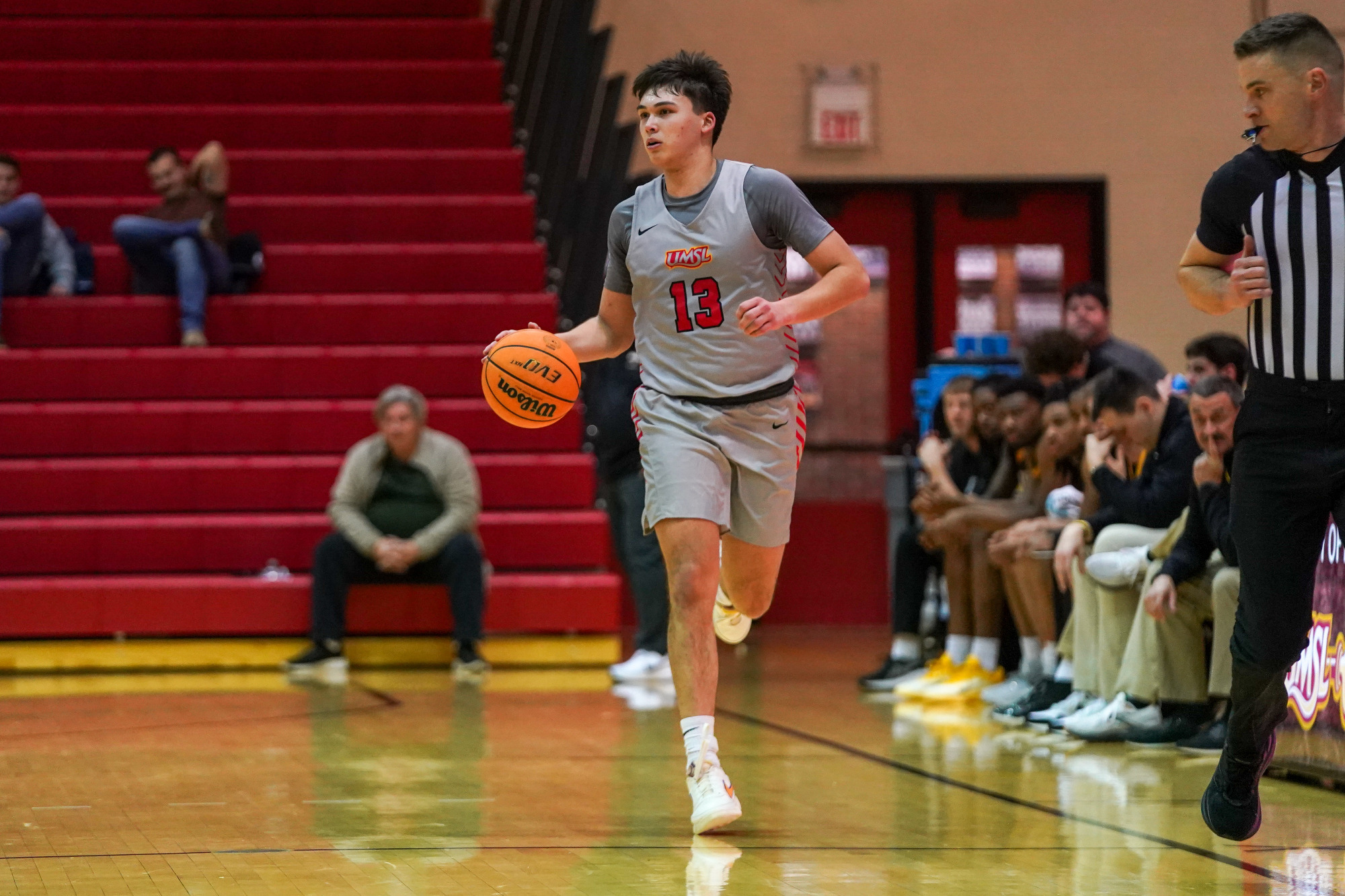 Miles Boland dribbles the basketball upcourt looking to make a pass