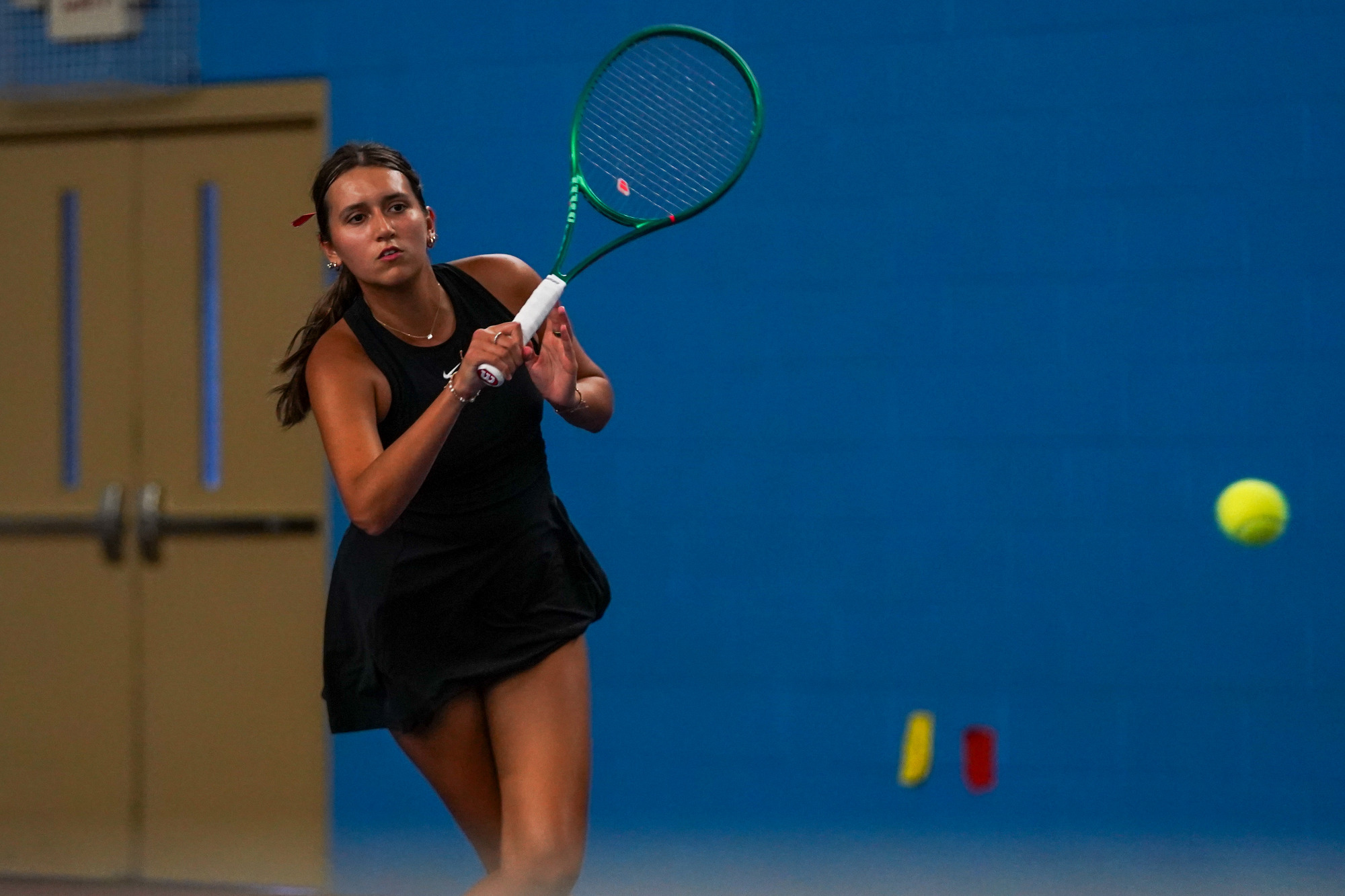 Aleksandra Lopez returns a volley during a rally of a tennis match