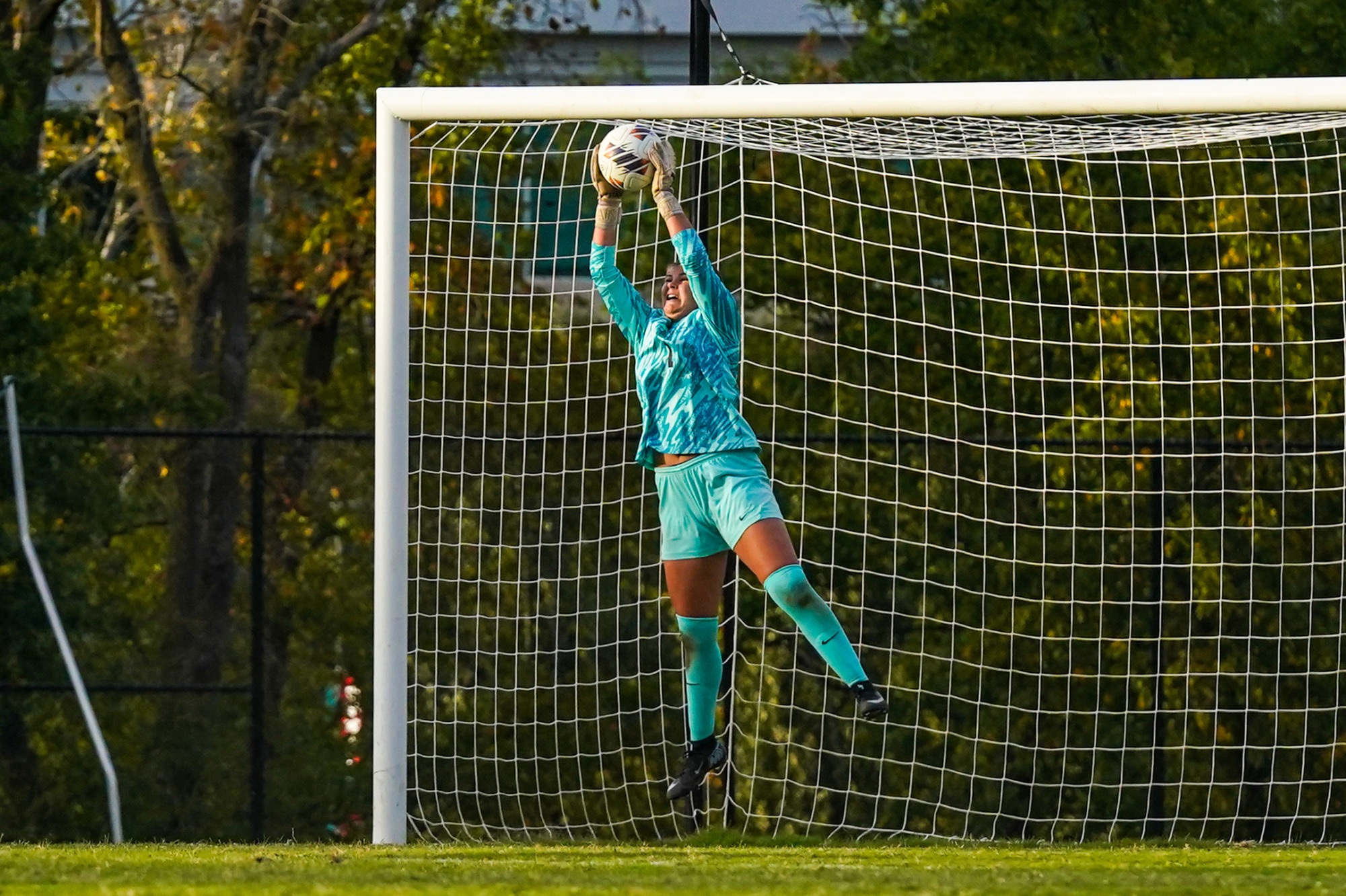 Allysa Wolf makes a leaping save in a women's soccer game against Rockhurst.