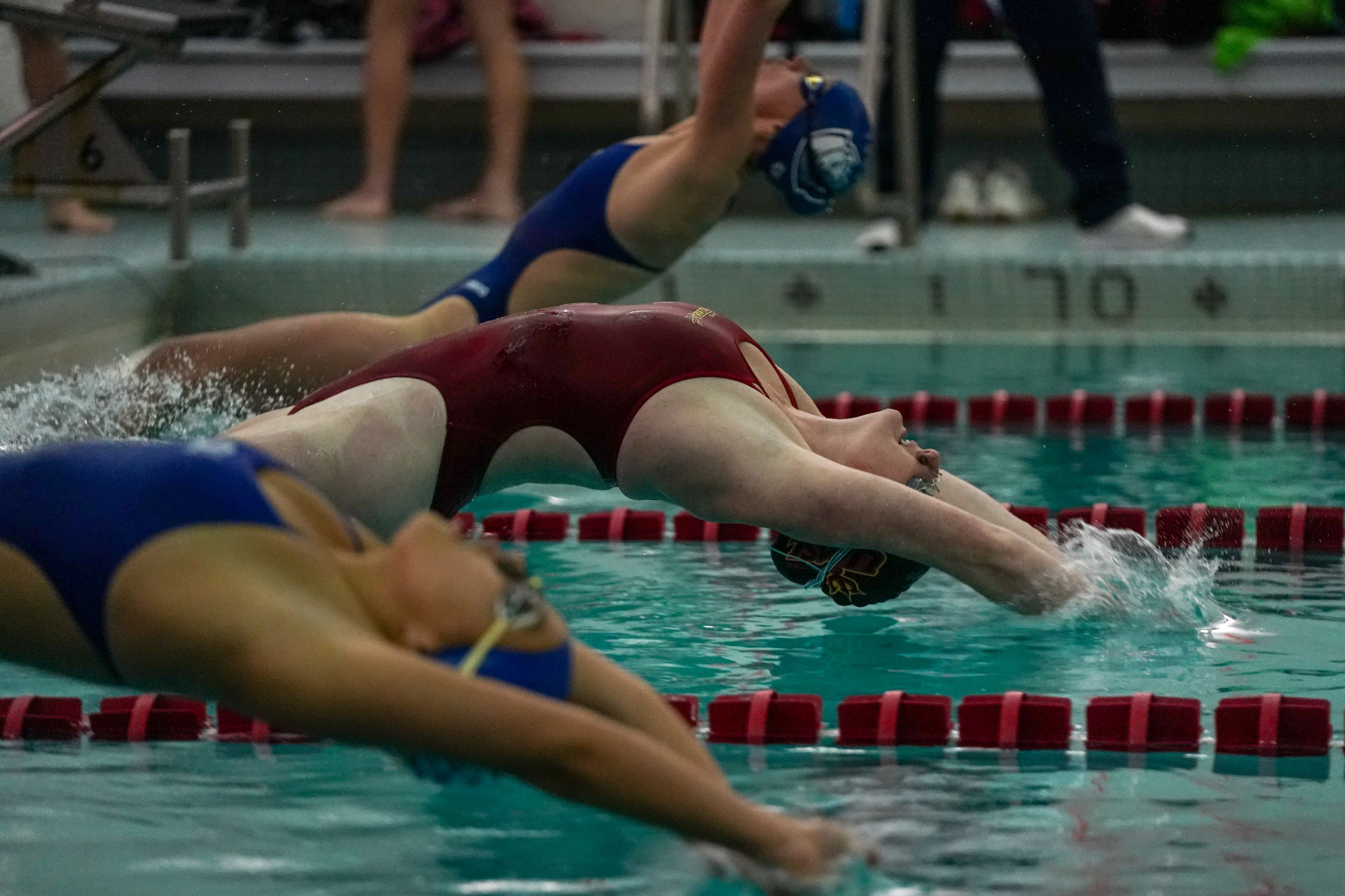 Ella Lantz comes off the starters block in a back stroke event against Saint Louis University