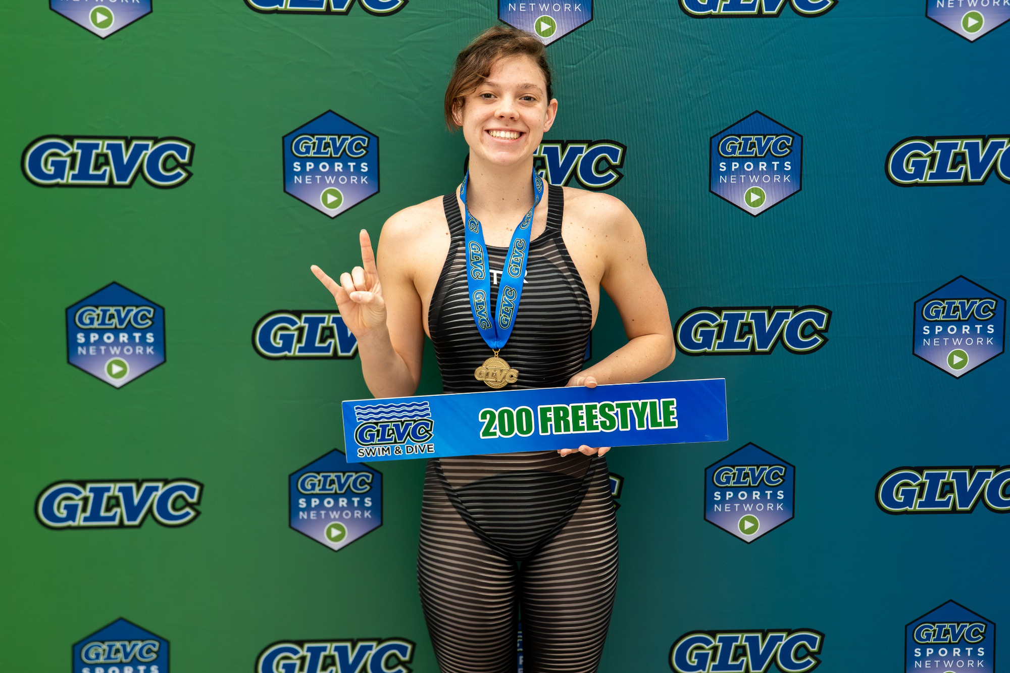 Justice Beard poses with her second gold medal and the 200-yard freestyle sign after coming from behind to win the 200 free on Thursday.