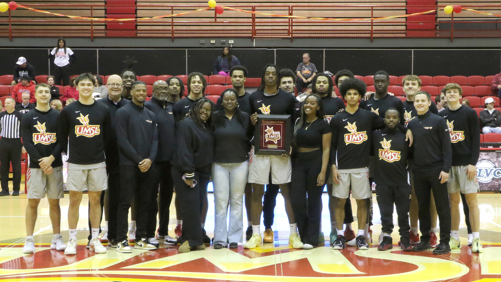 Blessed Barhayiga, front center, holding his senior day gift was surronded by his mother, sisters, teammates and coaches in a group photo prior to the Senior Day win over William Jewell.