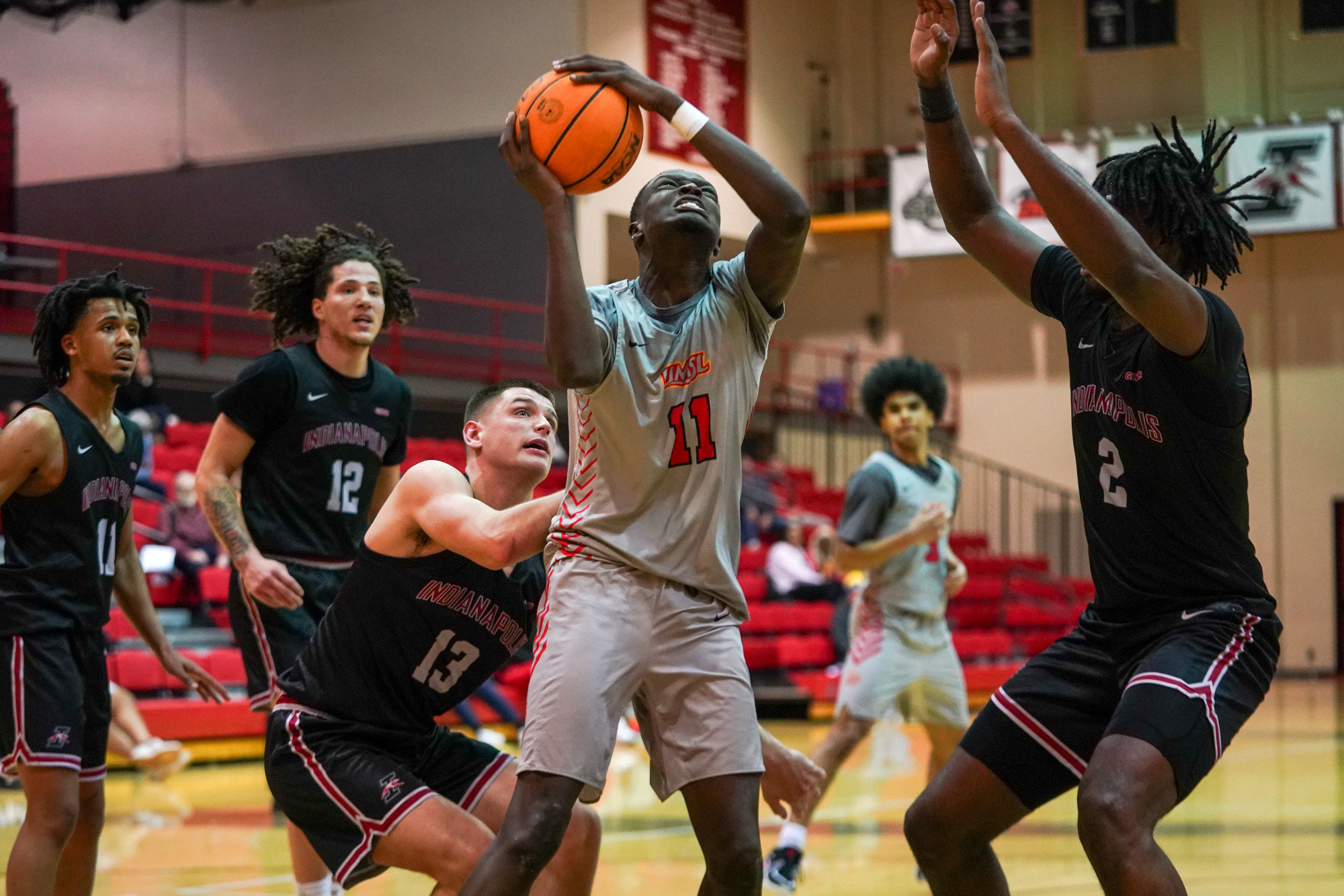 Makeer Makeer goes up for a shot against two University of Indianapolis defenders in a game on February 5, 2026 at the Mark Twain Building.