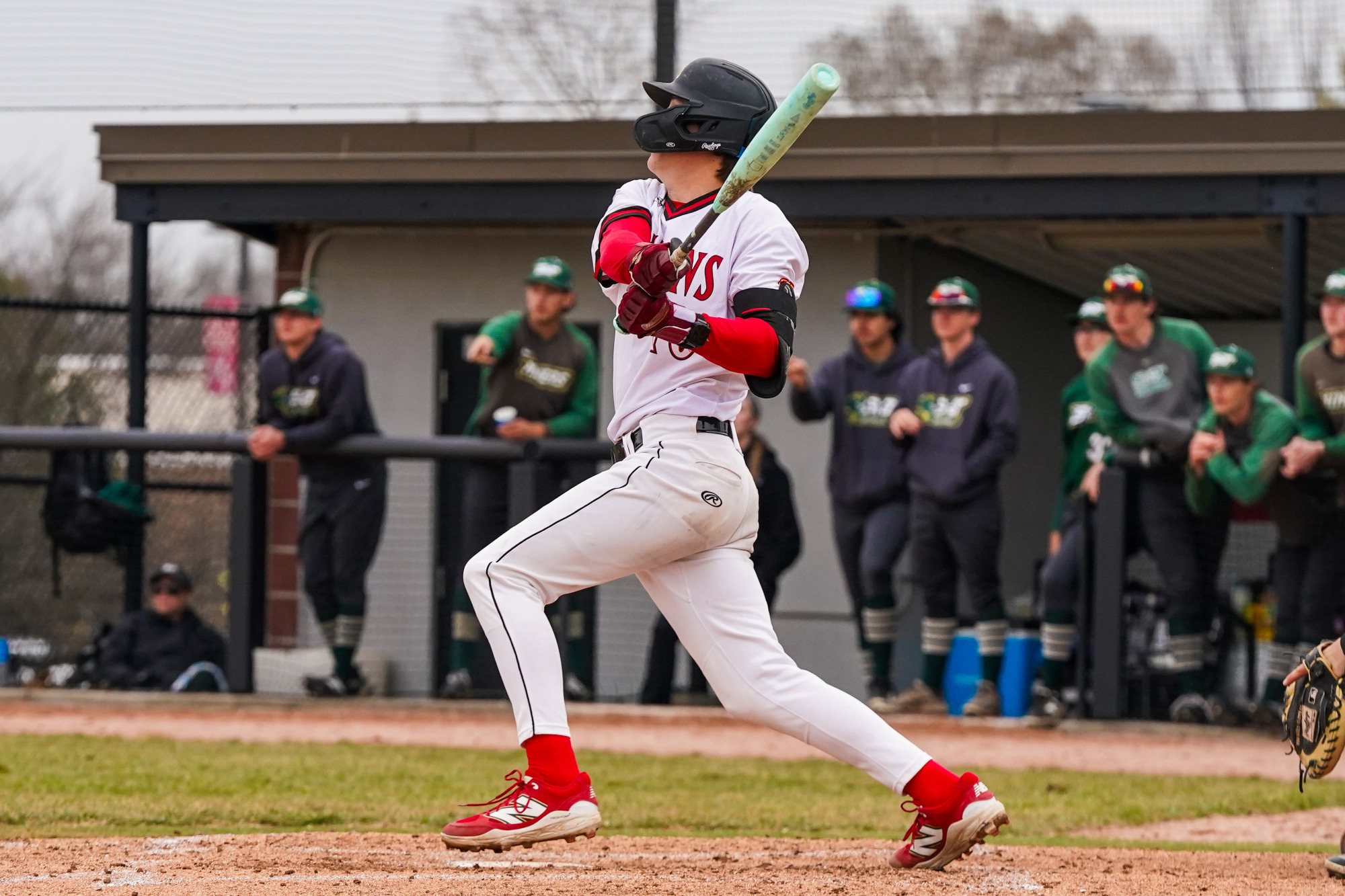 Brandon Johnson follows through on his swing as he watches a baseball in flight.