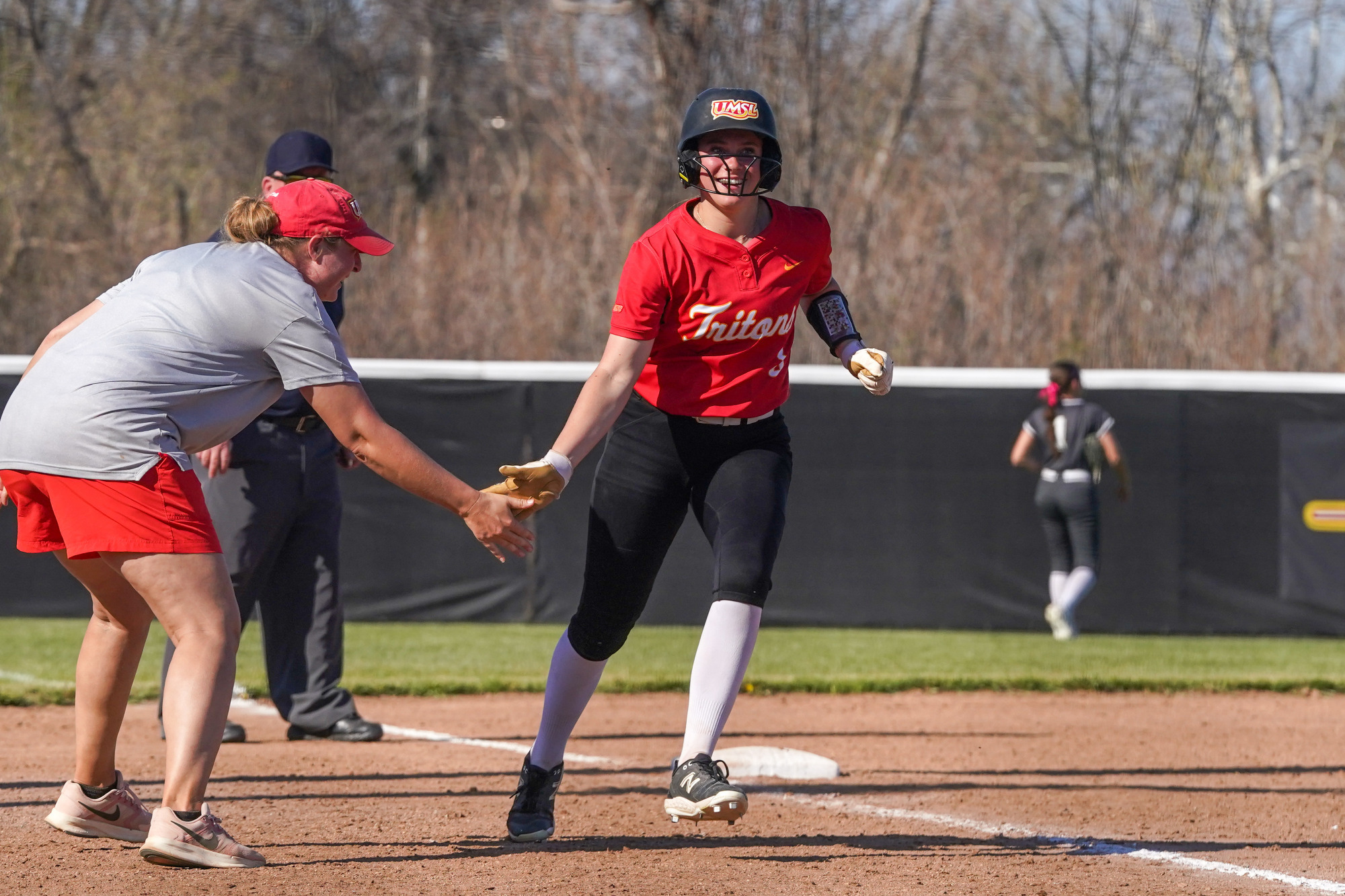 Kiley Sullivan rounds third and receives a low-five from head coach Chelsey Mulligan after hitting a three-run home run on Saturday afternoon.