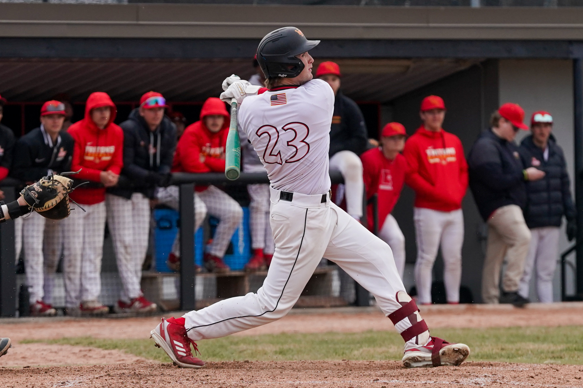 Owen Faith follows through with his swing after putting a baseball in play.