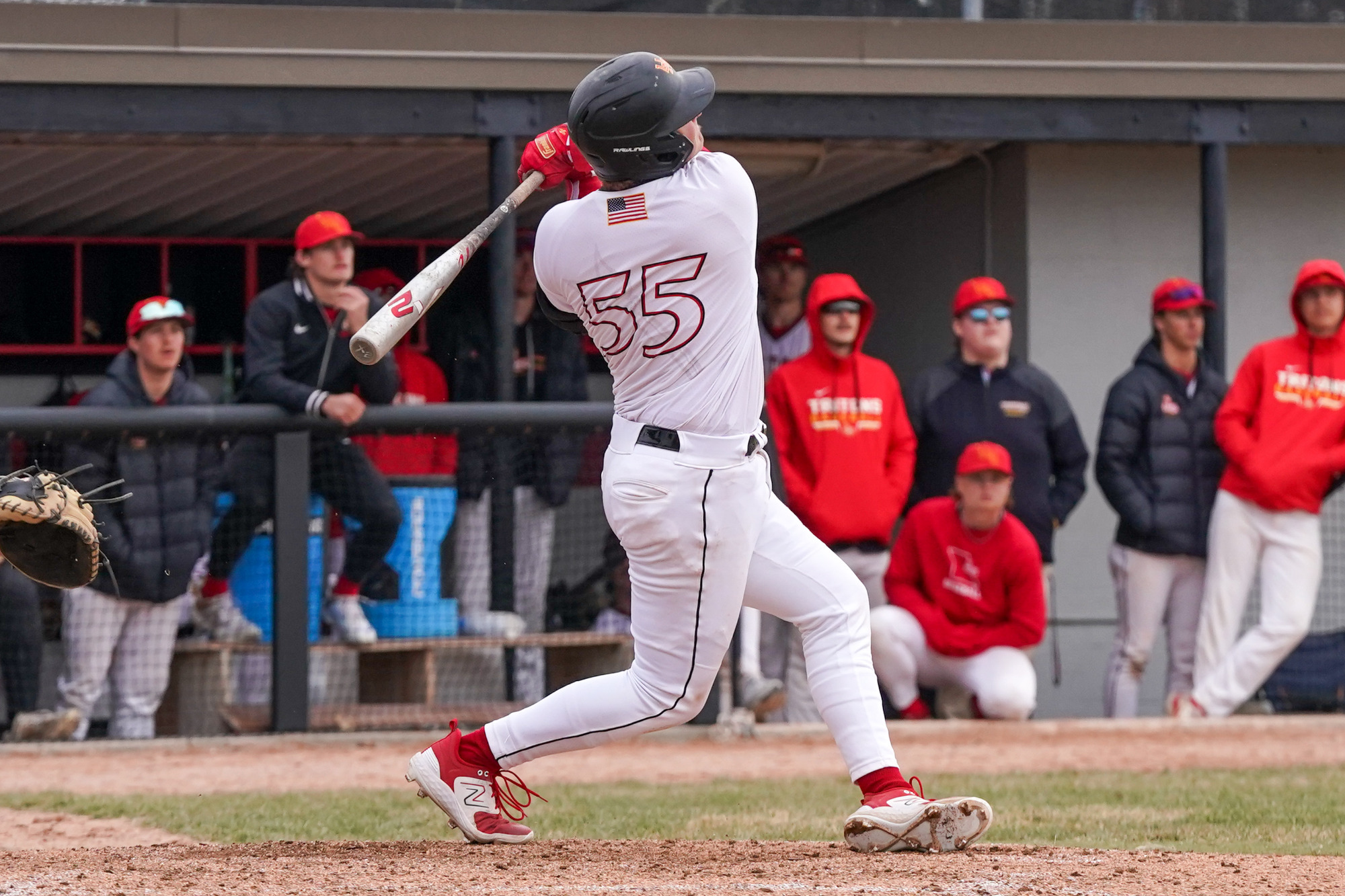 Justin Simard follows through on his swing after striking a pitched ball.