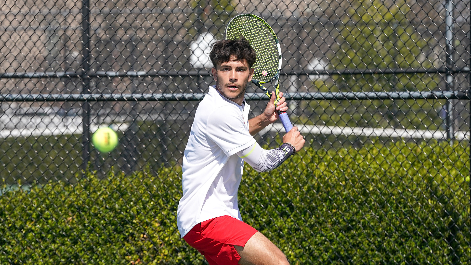Andrea Ricart prepares to hit a backhand shot in a men's tennis match