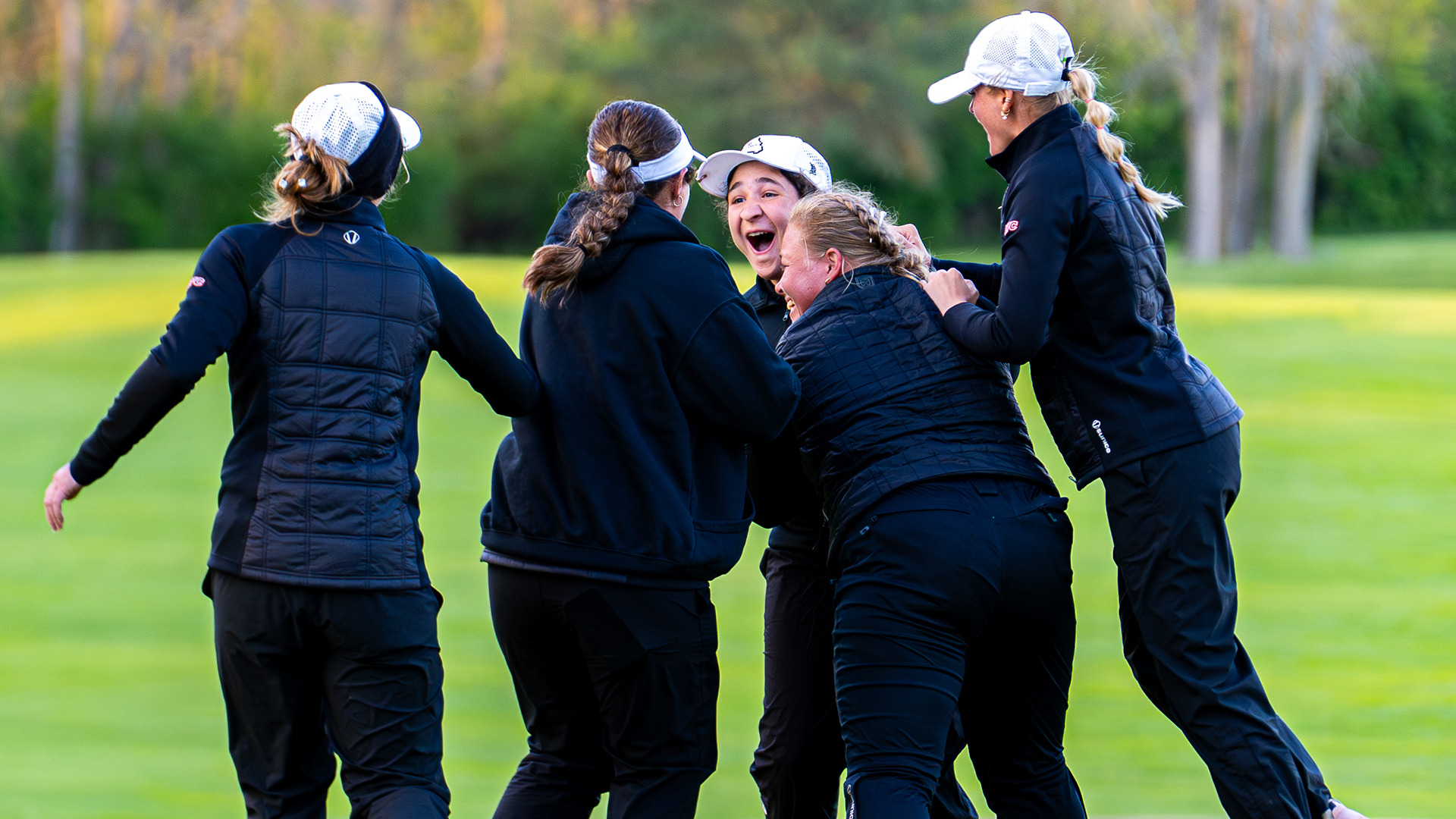 UMSL's women's golf team celebrates on the 18th green after winning the 2026 Great Lakes Valley Conference championship