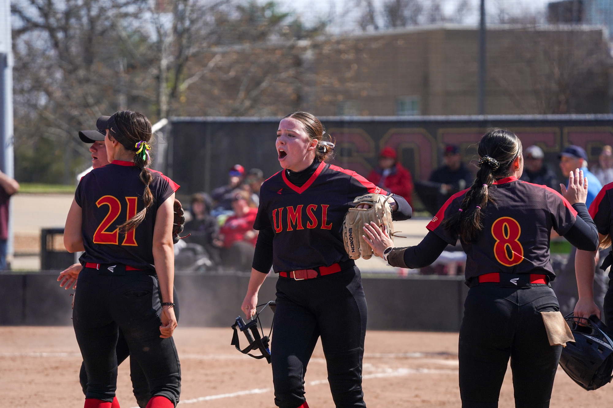 UMSL Softball players congratulate each other after coming off the field and get ready to bat