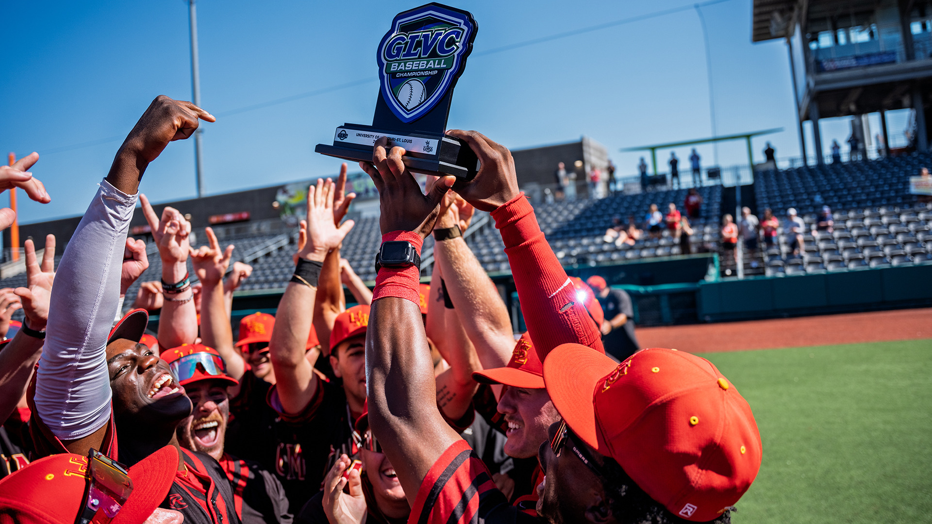 UMSL baseball players celebrate after receiving the Great Lakes Valley Conference championship trophy