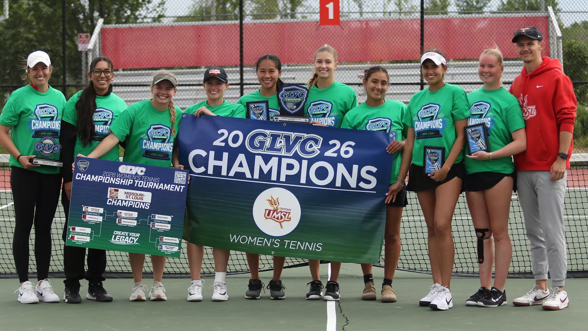 UMSL Women's Tennis won the 2026 Great Lakes Valley Conference Championship on Sunday (May 3). The Players and Coaches are holding the championship match sign and GLVC Championship banner. Pictured L-R: Head Coach Megan Holdridge, Alexandra Cedeno, Lauren Sweeney, Morgan Lint, Hannah Tse, Anna Favaron, Giuliana Cunza, Aleksandra Lopez, Millie Wileman and Assistant Coach Trey Murphy.