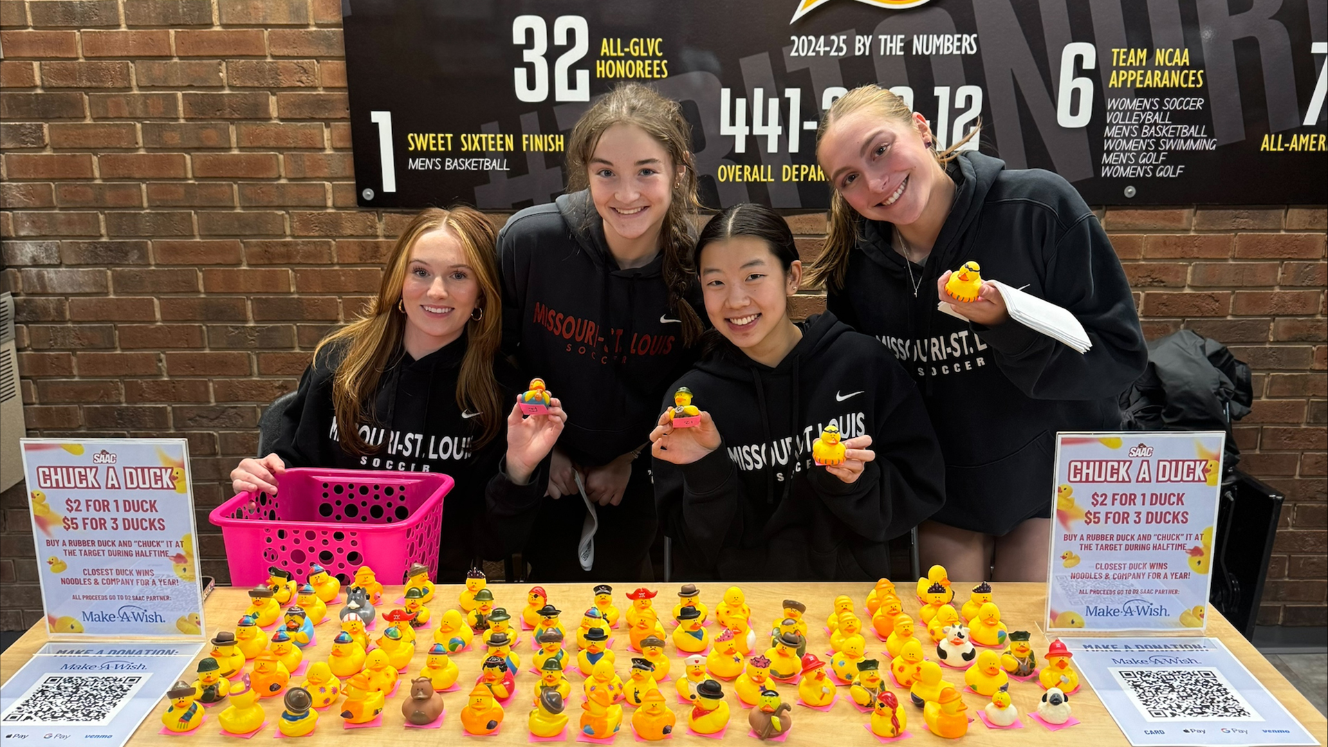 UMSL Women's Soccer student-athletes sell rubber ducks at a basketball game to help raise money for Make-A-Wish. Front Row (L-R): Olivia Lautz and Lexi Whalen. Back row (L-R): Danni Cotter and Sophia Beedle.