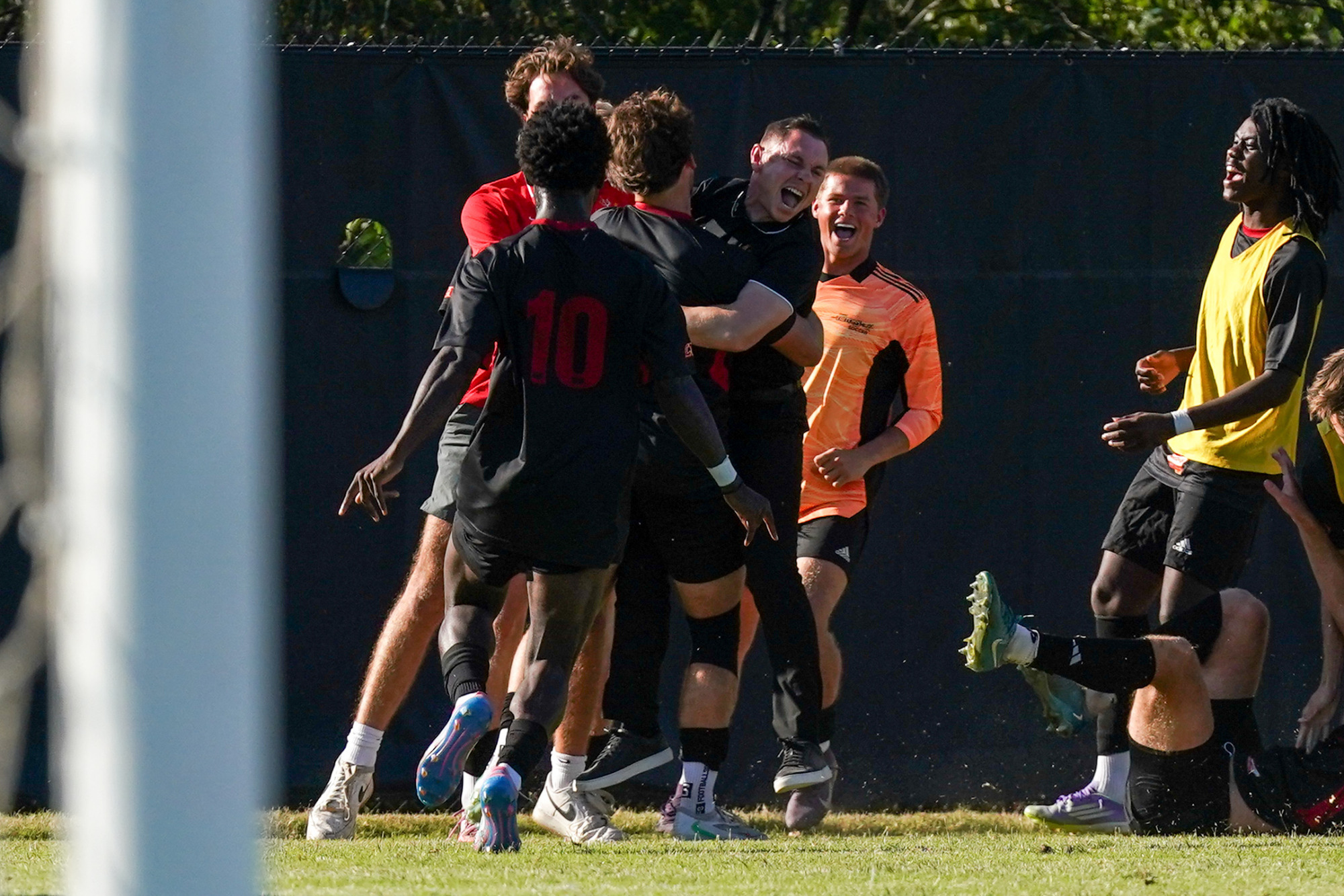 UMSL players celebrate with head coach Josh Alderson after scoring the game-winning goal against Illinois Springfield.