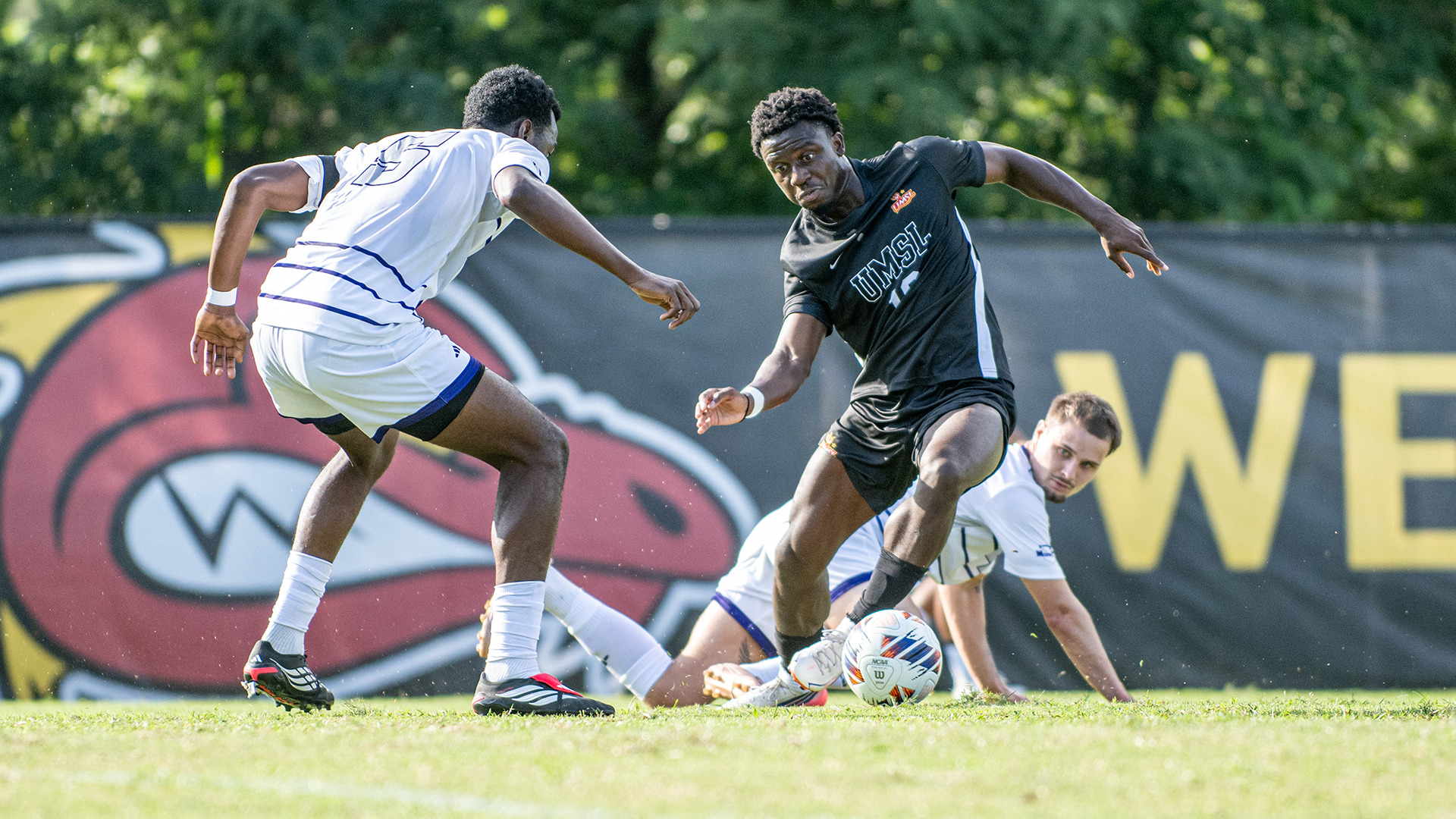 University of Missouri-St. Louis men's soccer forward Melo Mensah tries to dribble around a Kentucky Wesleyan Defender in an NCAA men's soccer contest