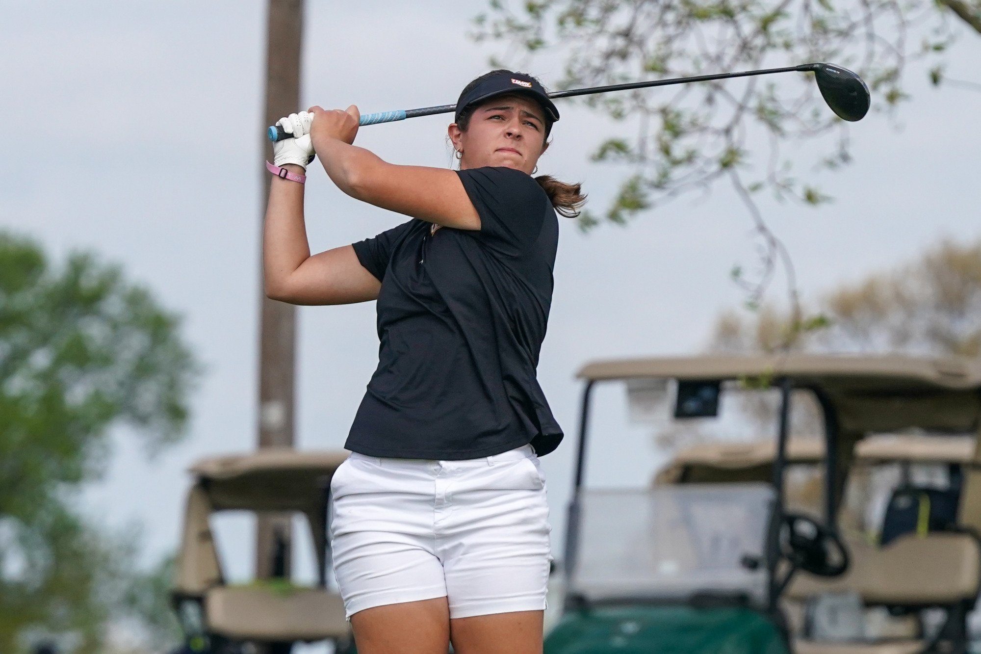 Alaina Ervin watches her drive after teeing off on a hole during the UMSL Spring Invitational