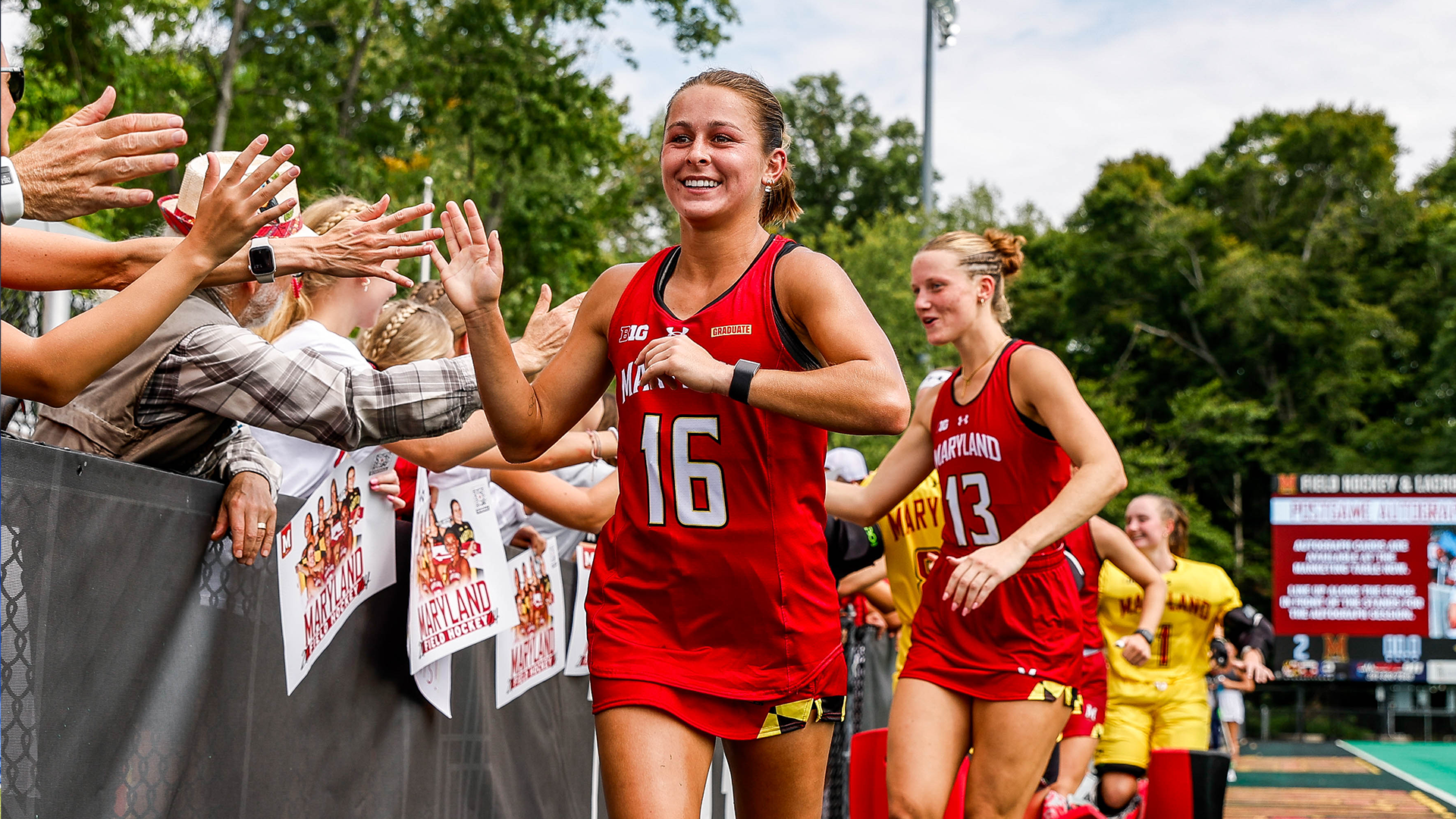 Emma DeBerdine running through high five line