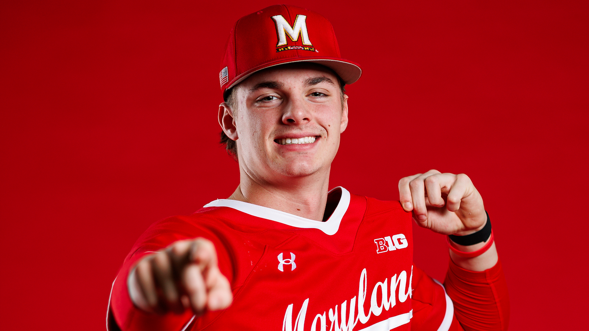 Story Cover Photo - Jake Yeager posing in front of red background pointing at camera