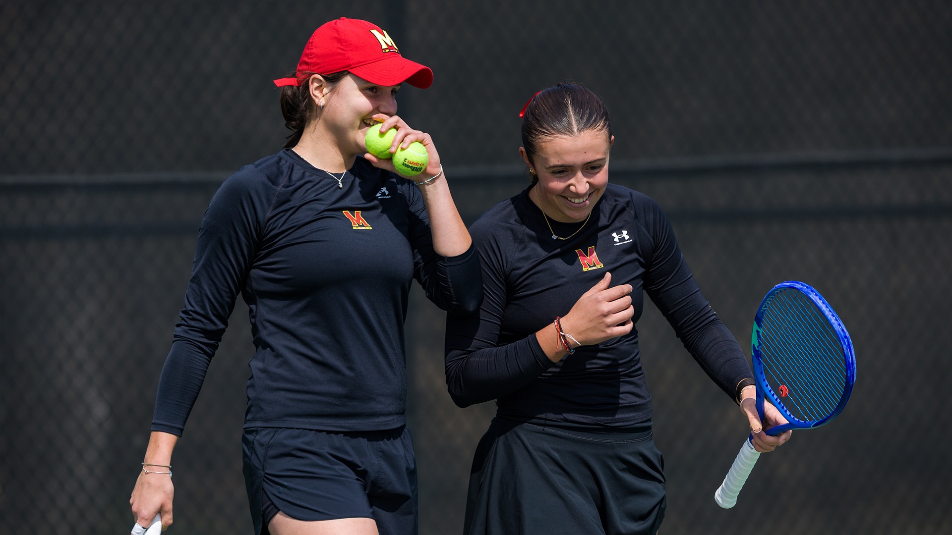 Emma Kovacevic and Emma Ghirardato conversing strategy during their doubles match versus Rutgers