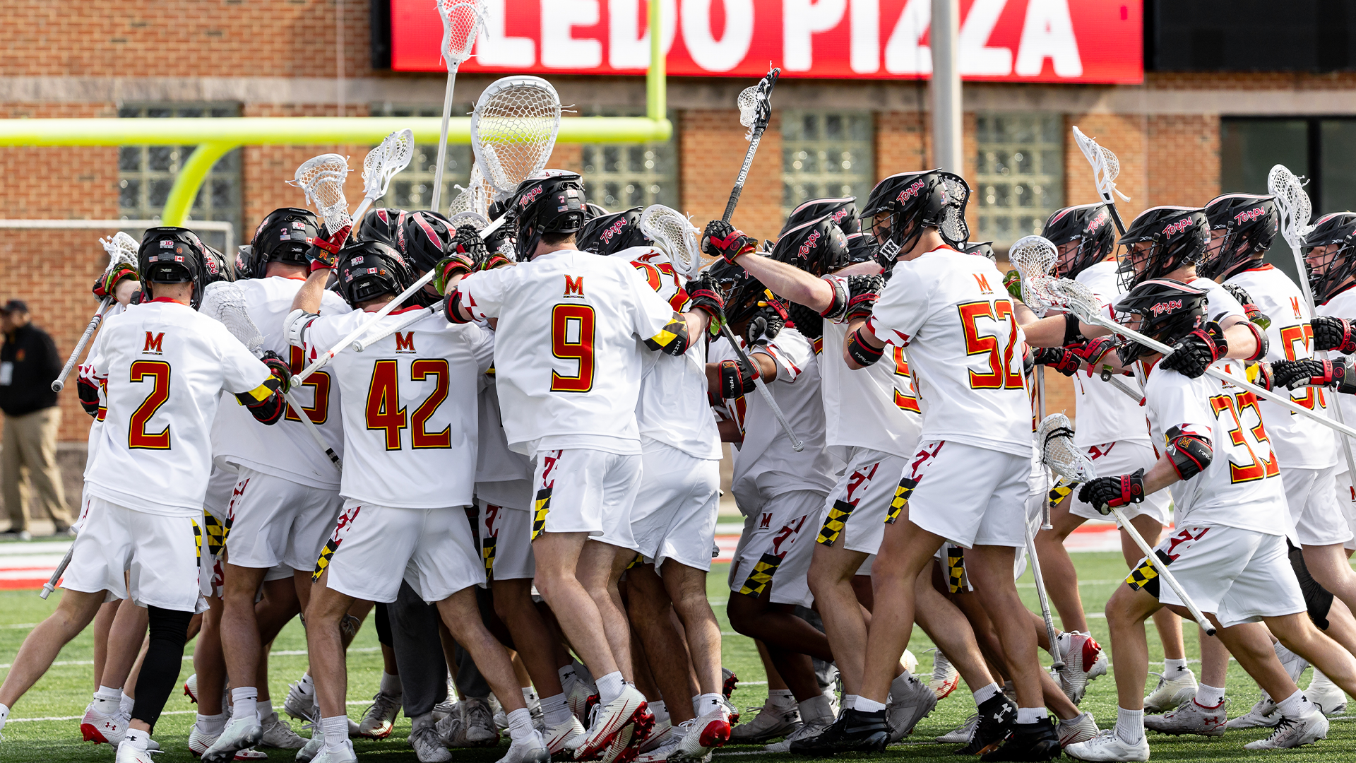 Men's lacrosse celebrating after beating UVA in triple-Overtime