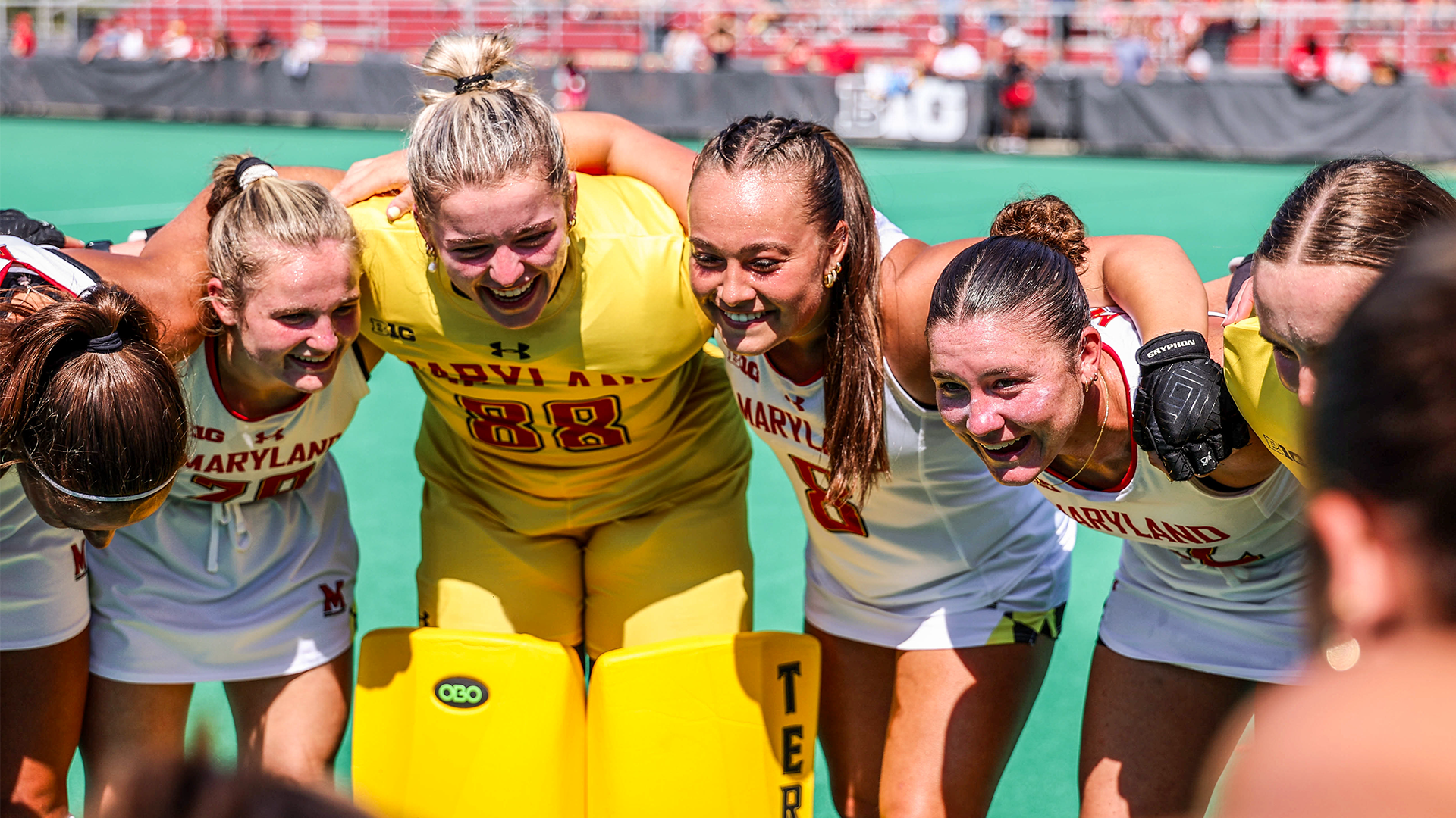 Field Hockey huddle while smiling