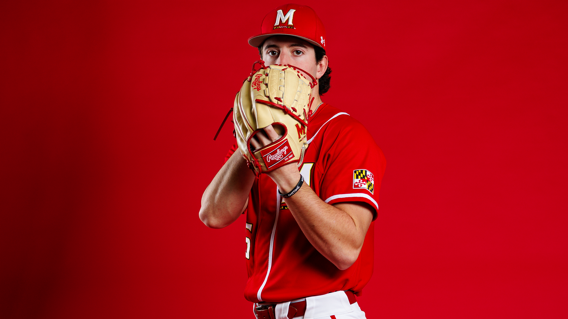 Logan Hastings Story Cover Photo - posing in front of red background with glove in hand