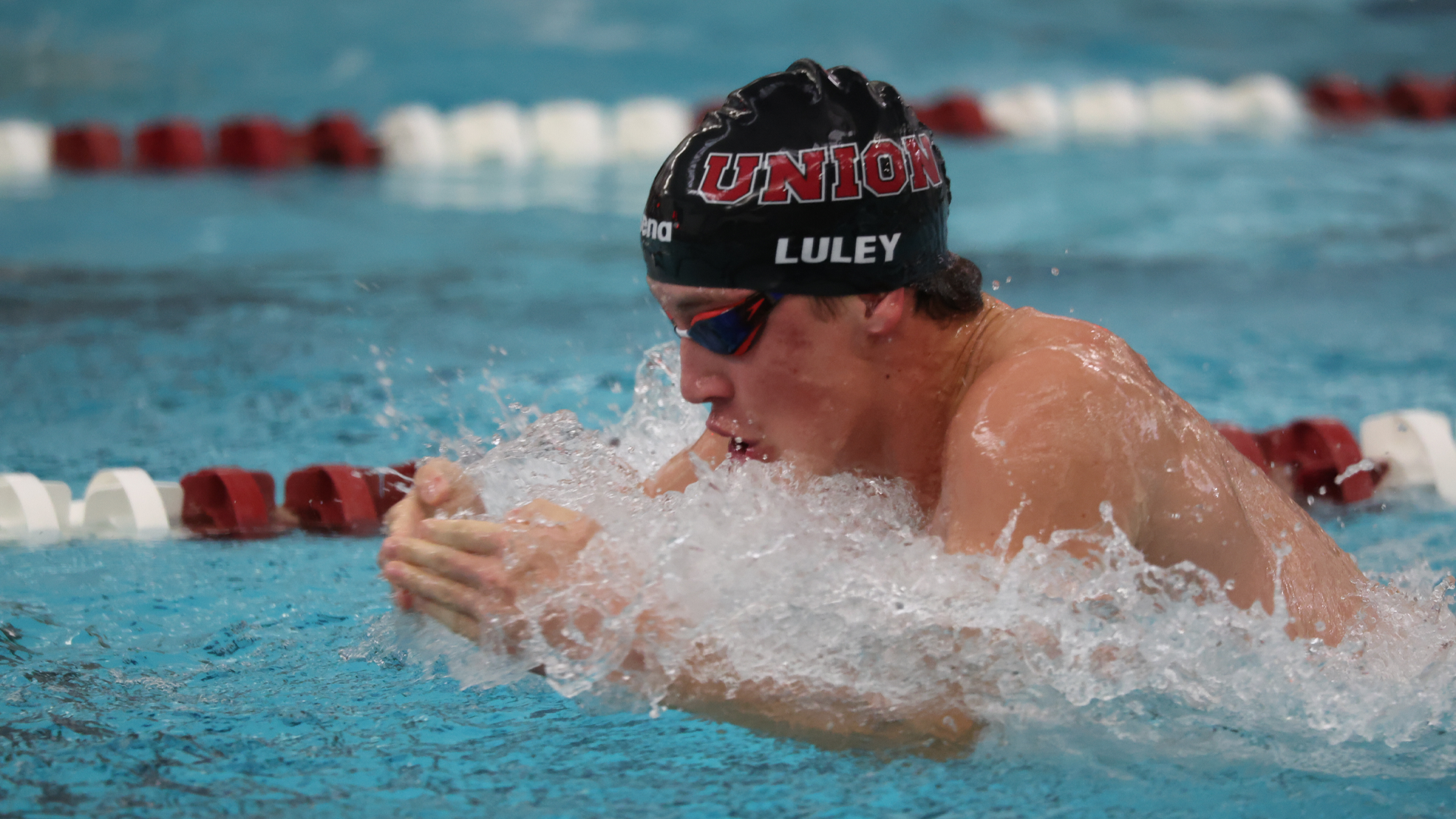 men's swimming student-athlete swimming the breaststroke
