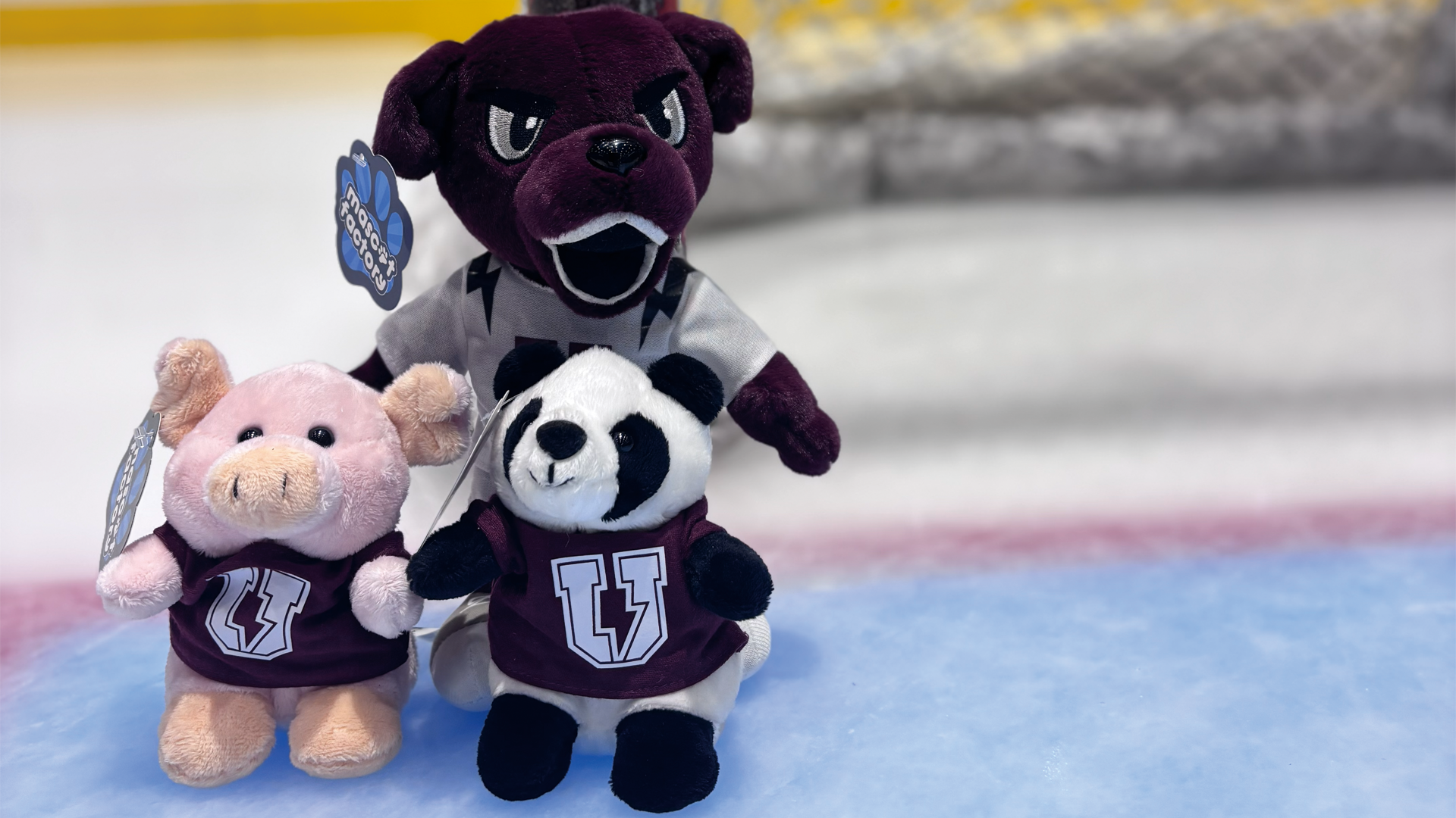 plush toy versions of a pig, panda, and Charger, Union's mascot grouped together on the ice
