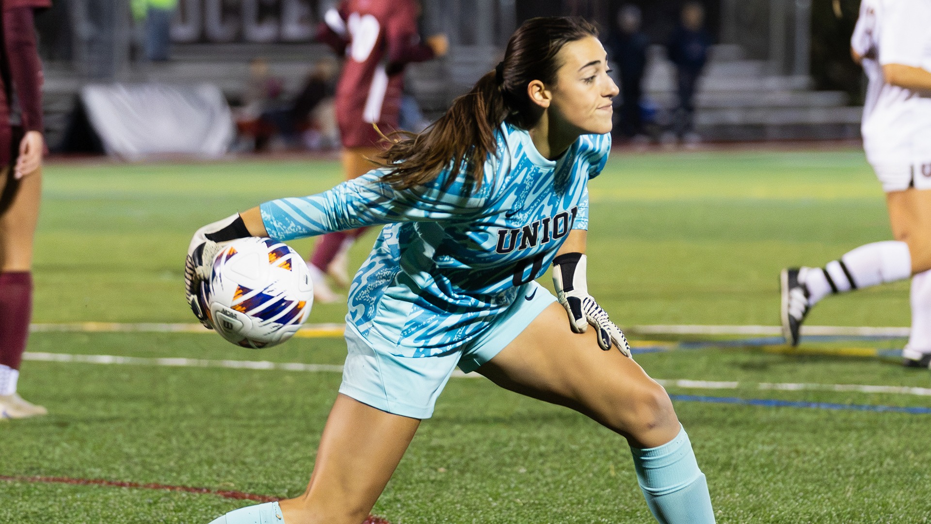 A goalie rolls the ball out to a teammate.