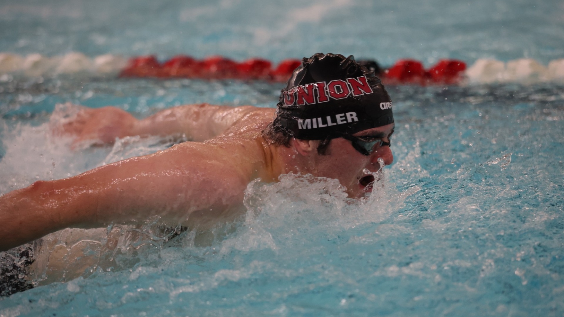a men's swimmer doing the fly