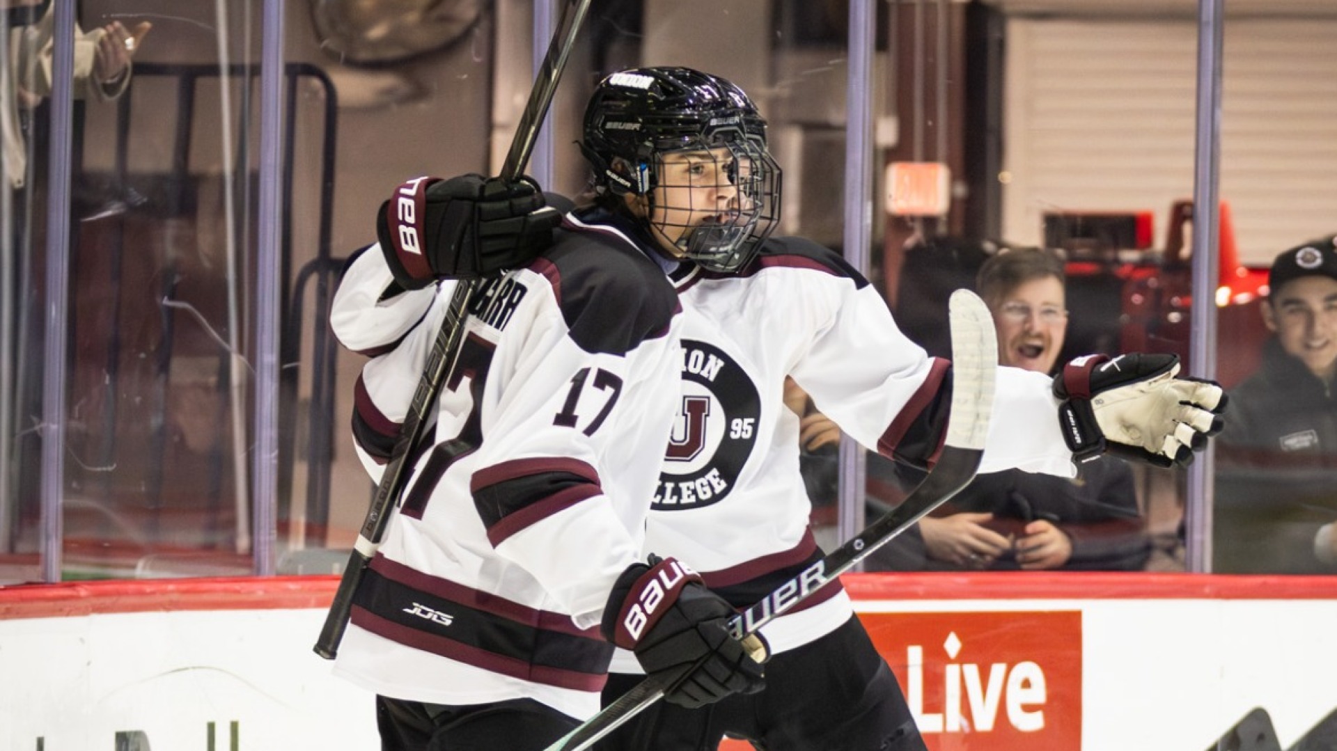 a men's hockey player hugging his teammate after a goal