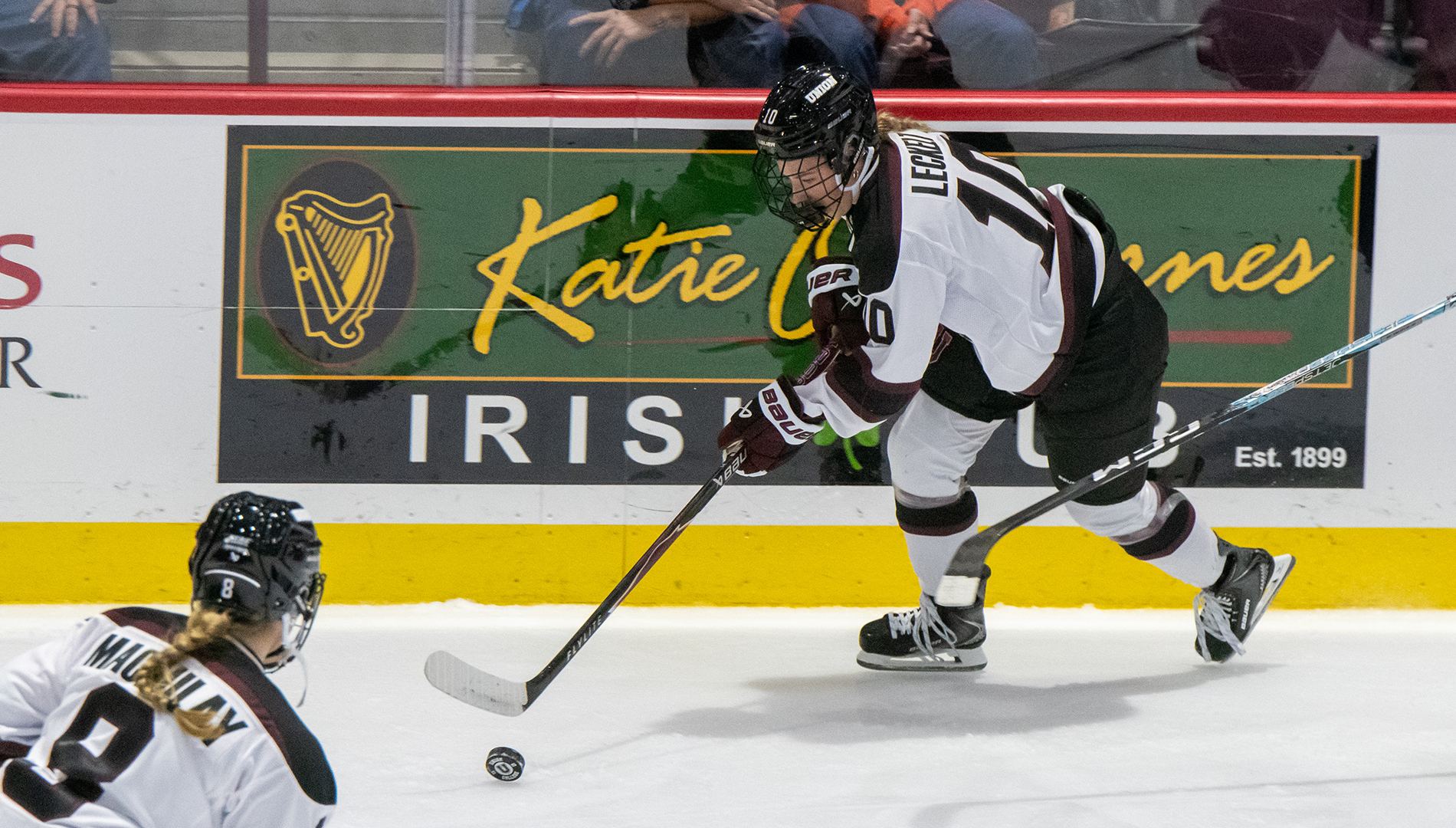 Union Hockey Women's Player attacking puck on bored 
